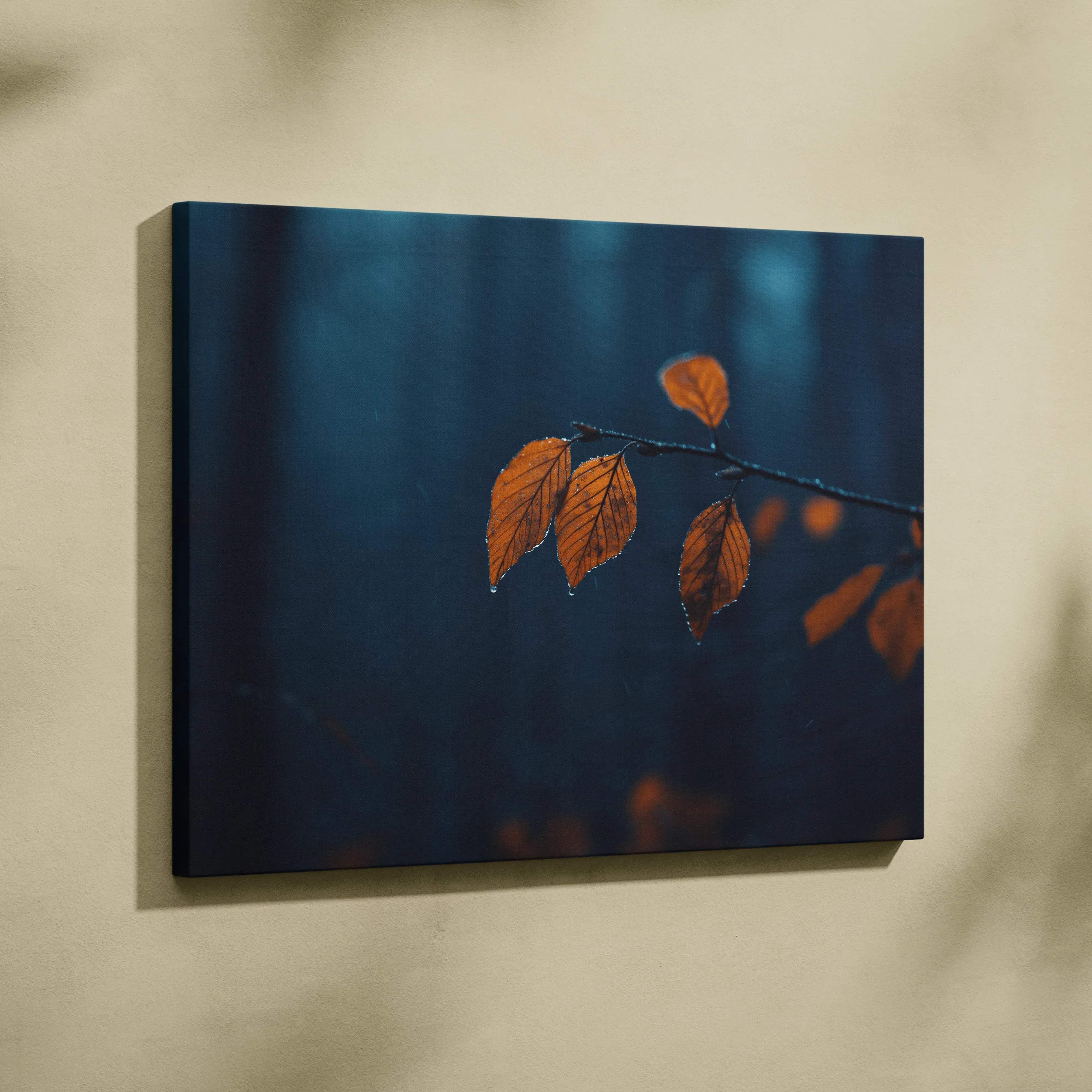 A rectangular canvas print of a branch with vibrant orange leaves on a deep blue blurred forest backdrop for living room decor