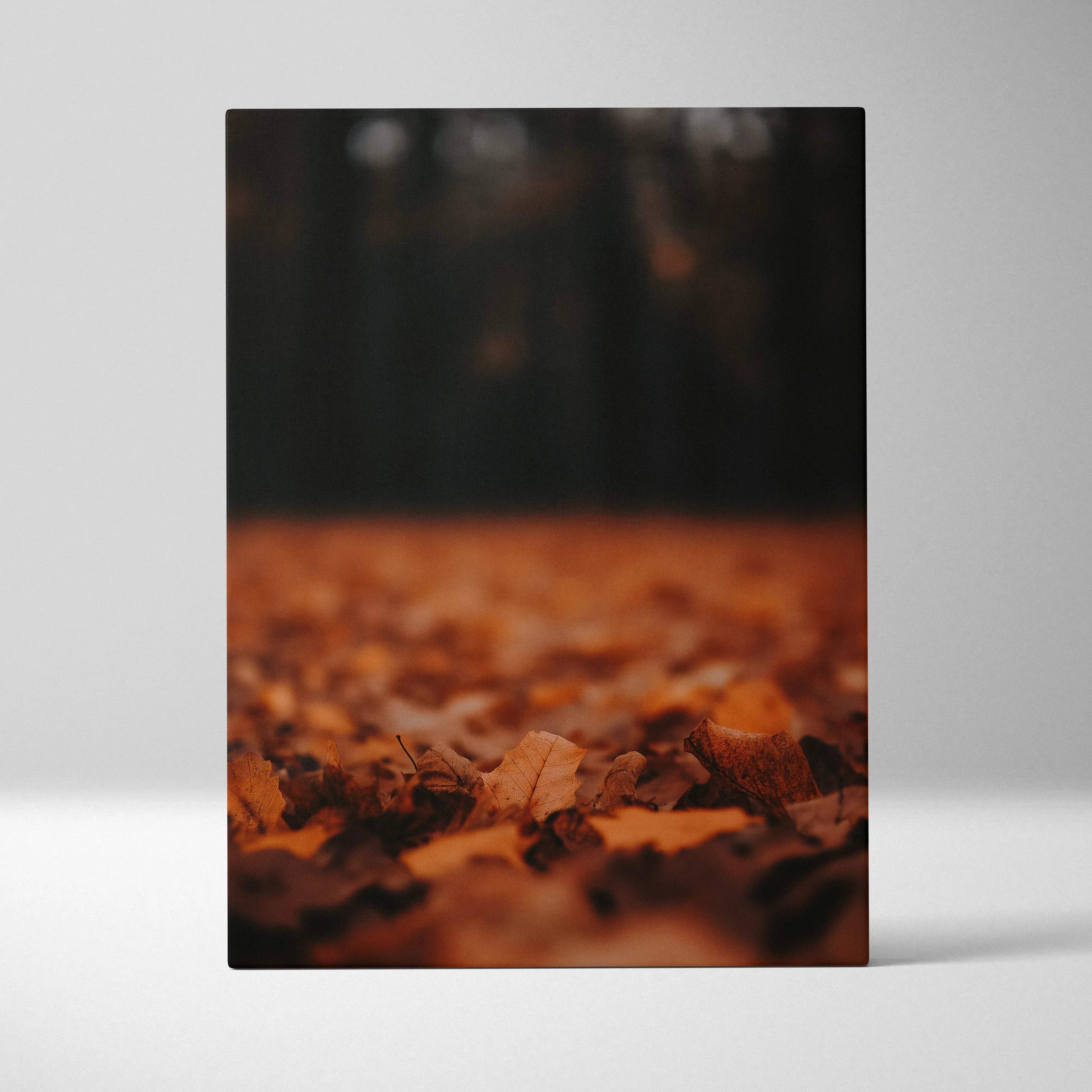 A rectangular canvas print of minimalist autumn leaves wall art featuring warm sepia tones and fallen forest floor leaves