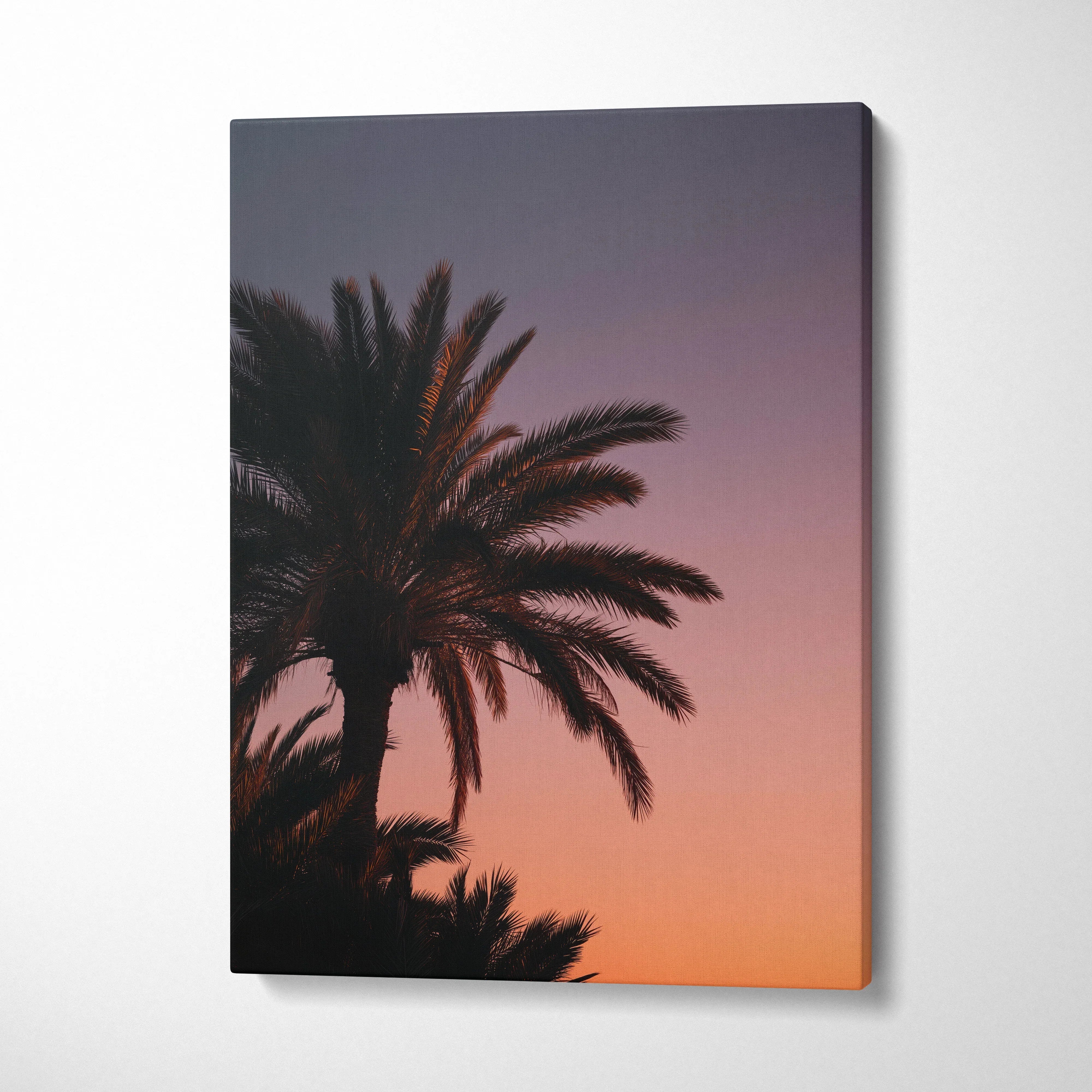 Canvas wall art of tropical palm tree silhouette against a vibrant sunset sky in warm purple and orange tones.