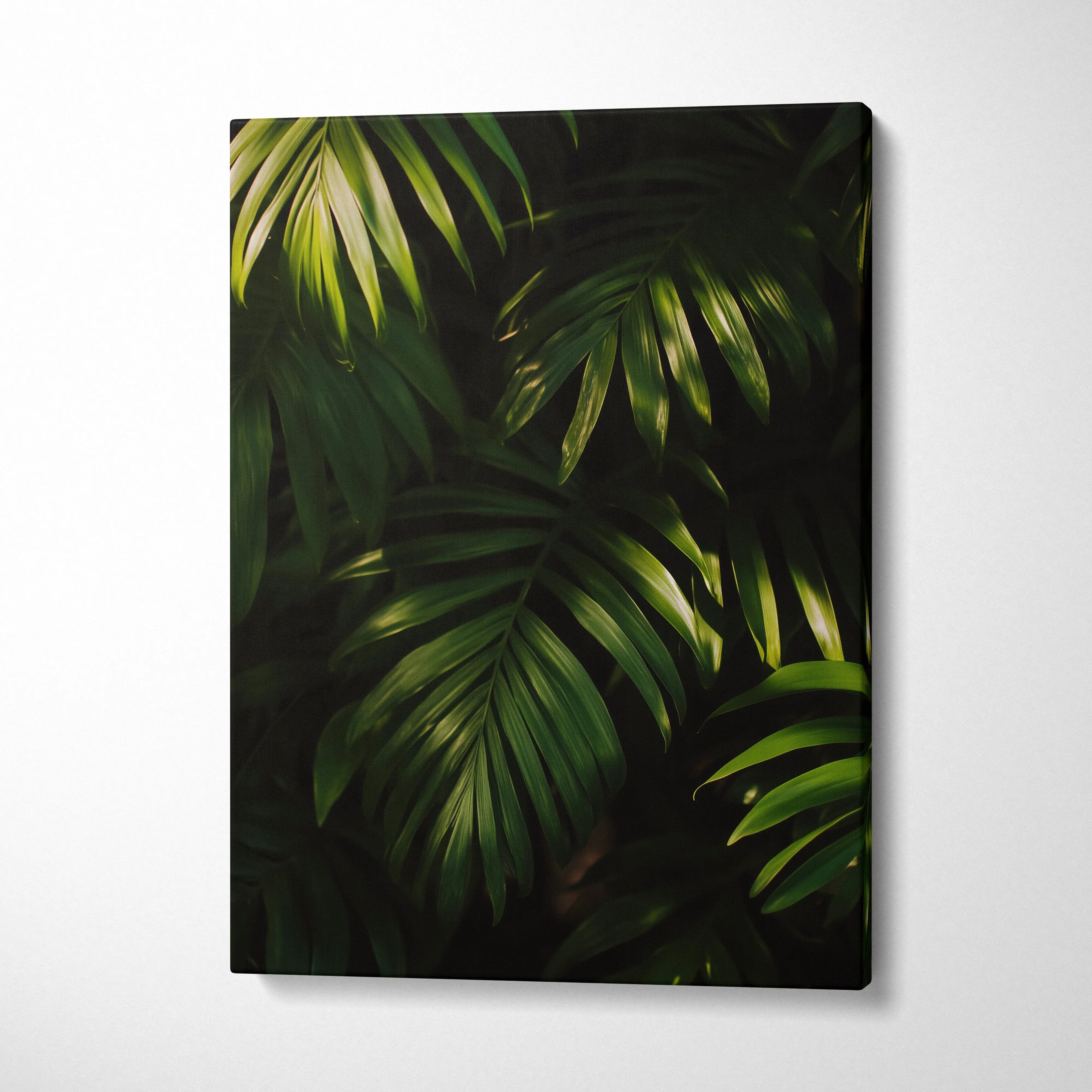 Vertical canvas wall art featuring vibrant tropical green leaves on dark background for modern decor.