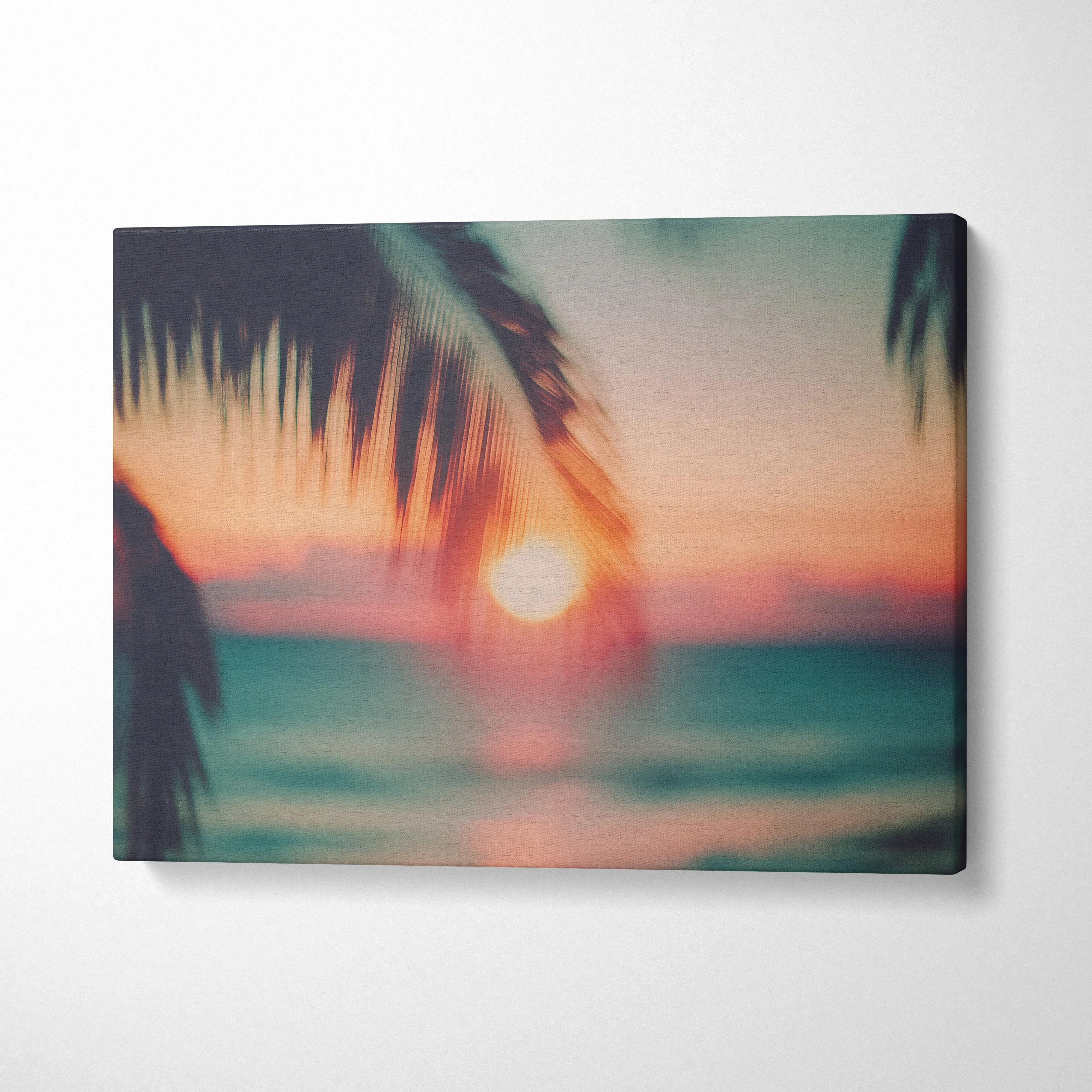 Canvas wall art featuring blurred tropical sunset with silhouette palm leaves in warm tones for home decor.