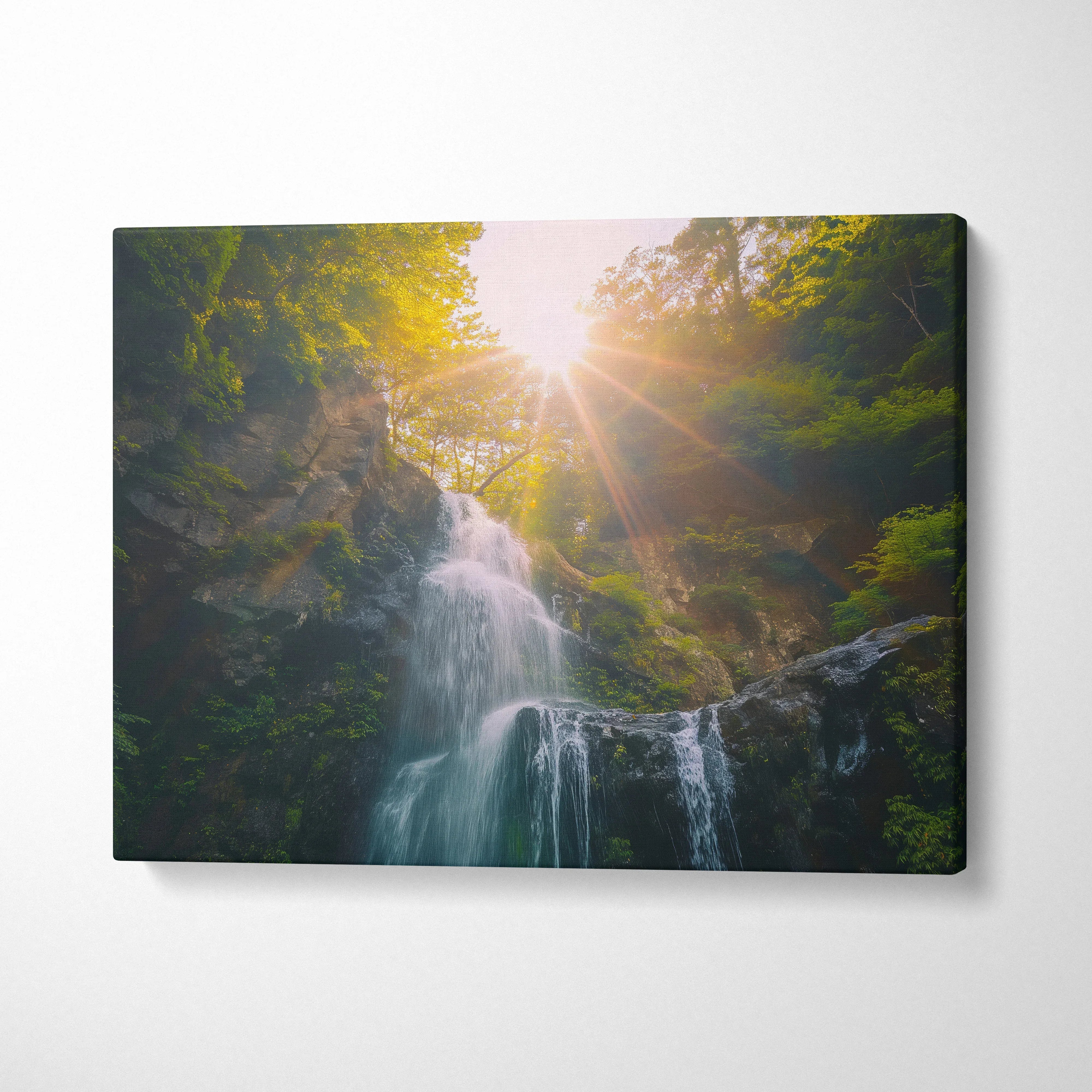 Waterfall nature canvas wall art with sun rays shining through green forest decor.