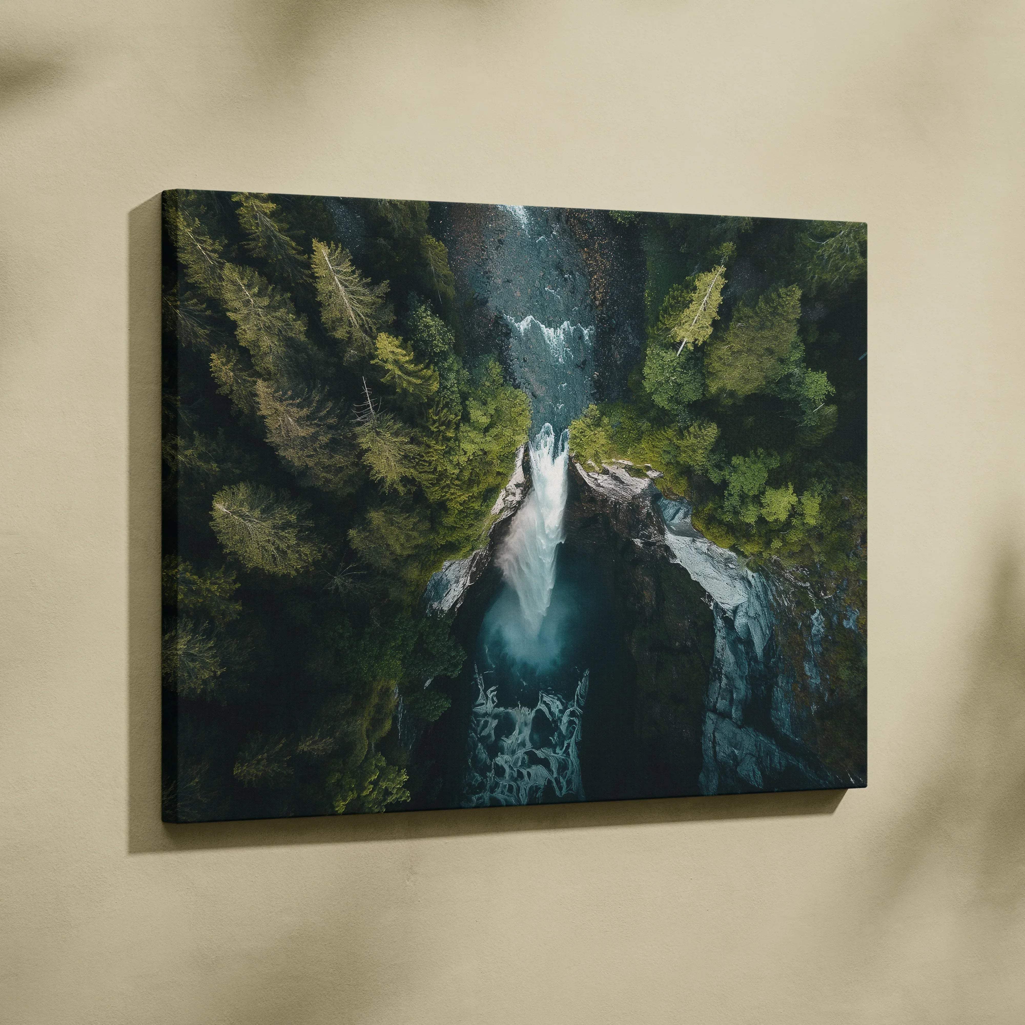 A framed canvas print of a dramatic aerial waterfall with emerald green forest and deep teal water for living room decor