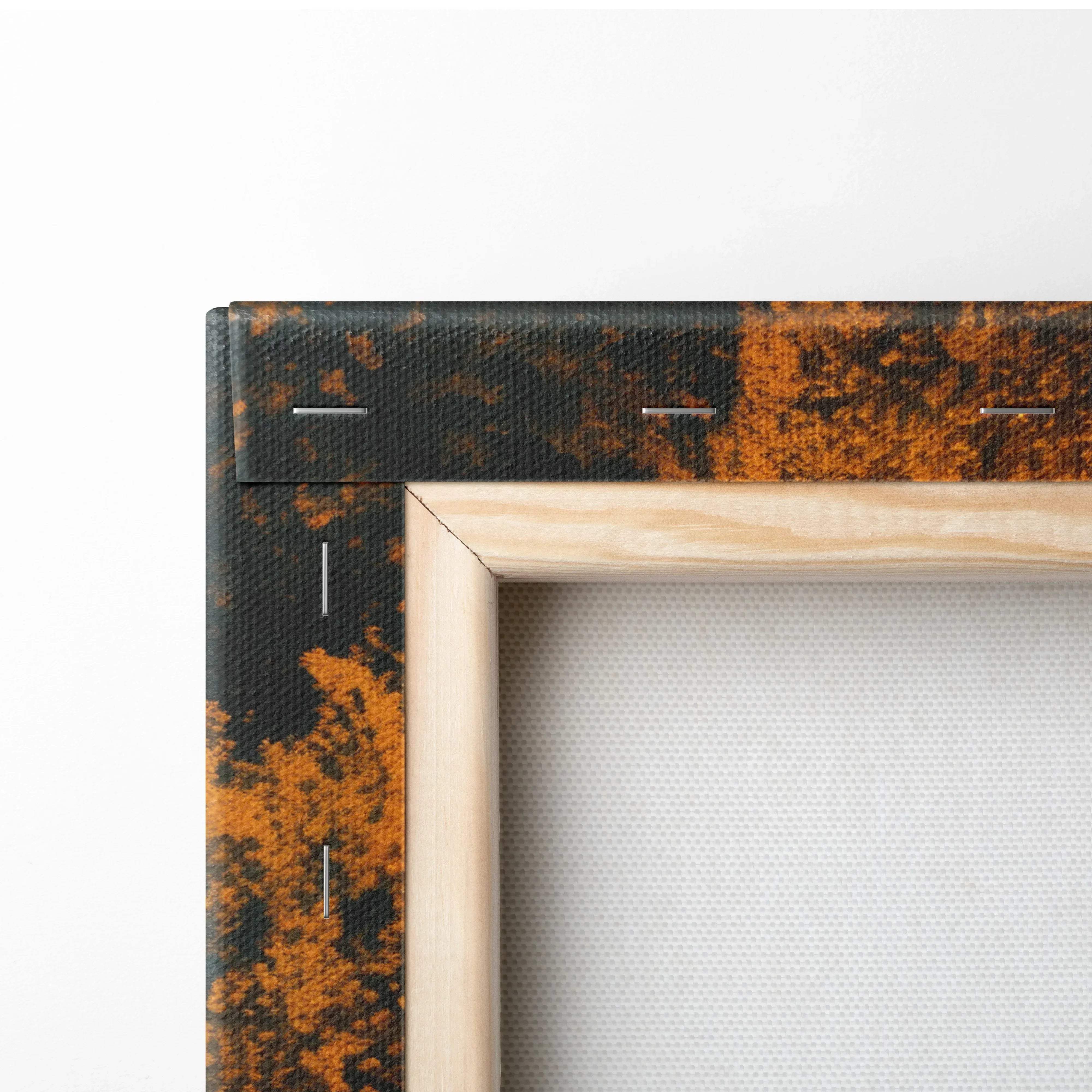 Light-colored wooden frame with canvas print of abstract rust and black pattern stitched edge for fine art wall decor