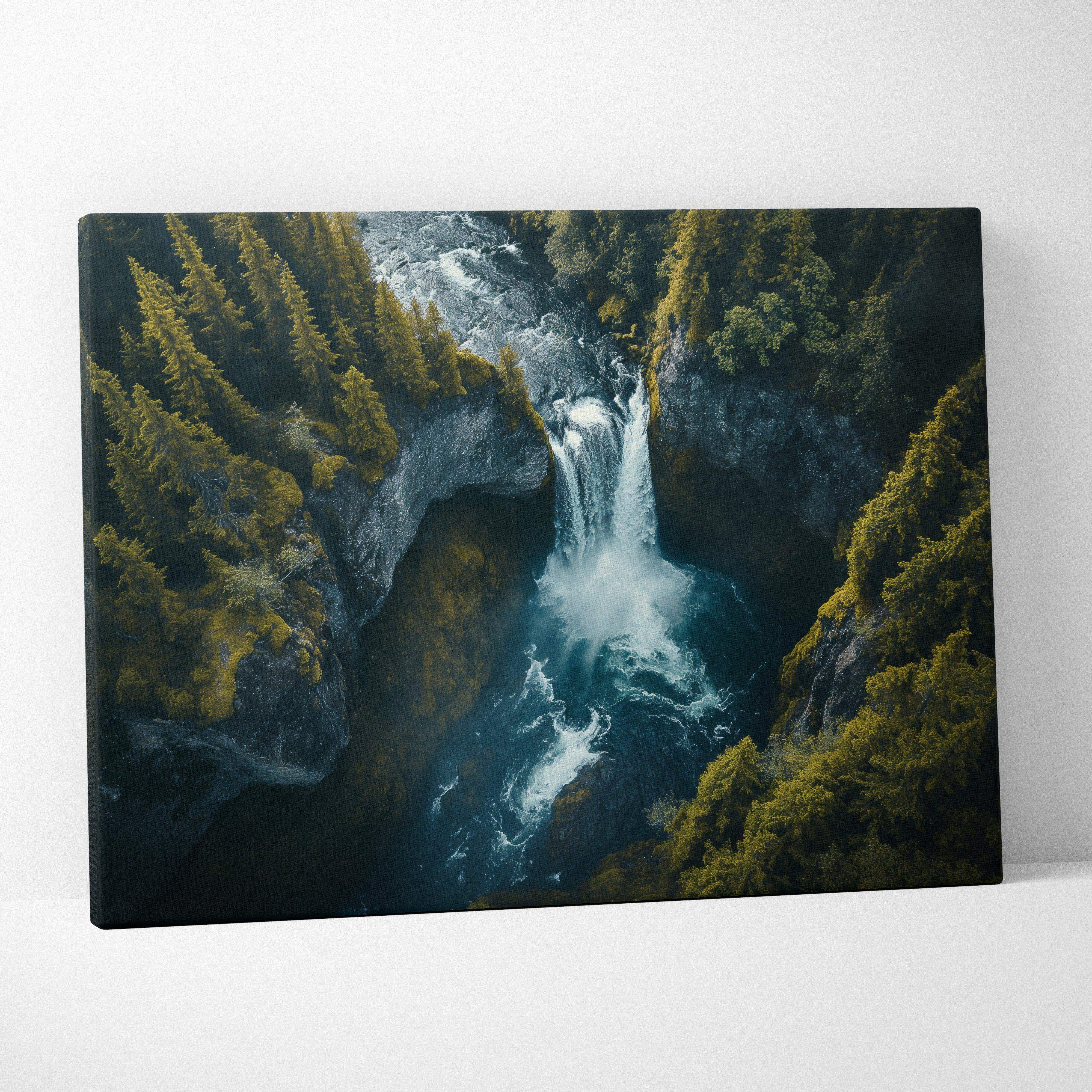 Rectangular canvas print of a moody blue and emerald green iceland waterfall landscape with dense evergreens and rocks