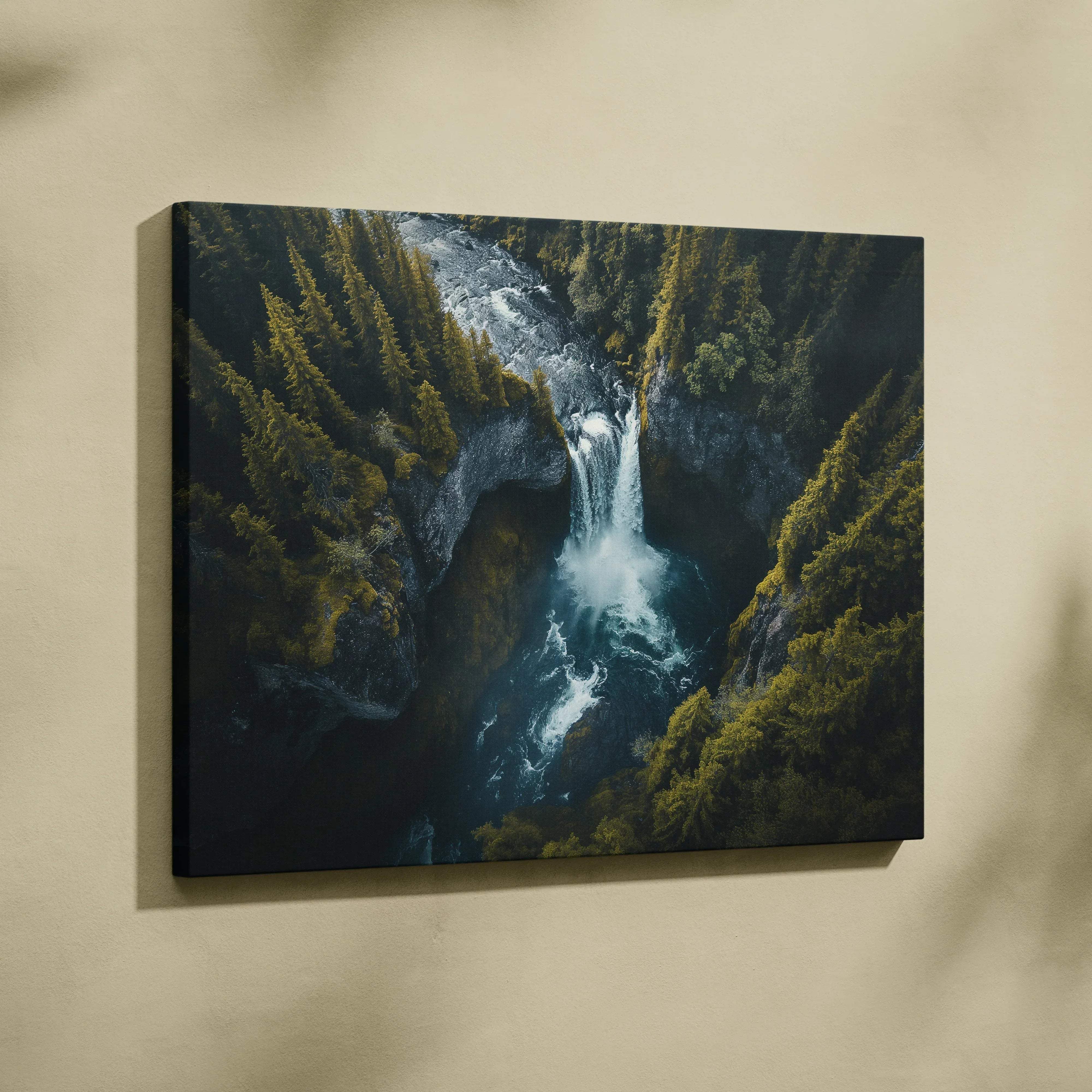 A framed canvas print of an iceland waterfall landscape with moody blues and emerald greens in a nature scene