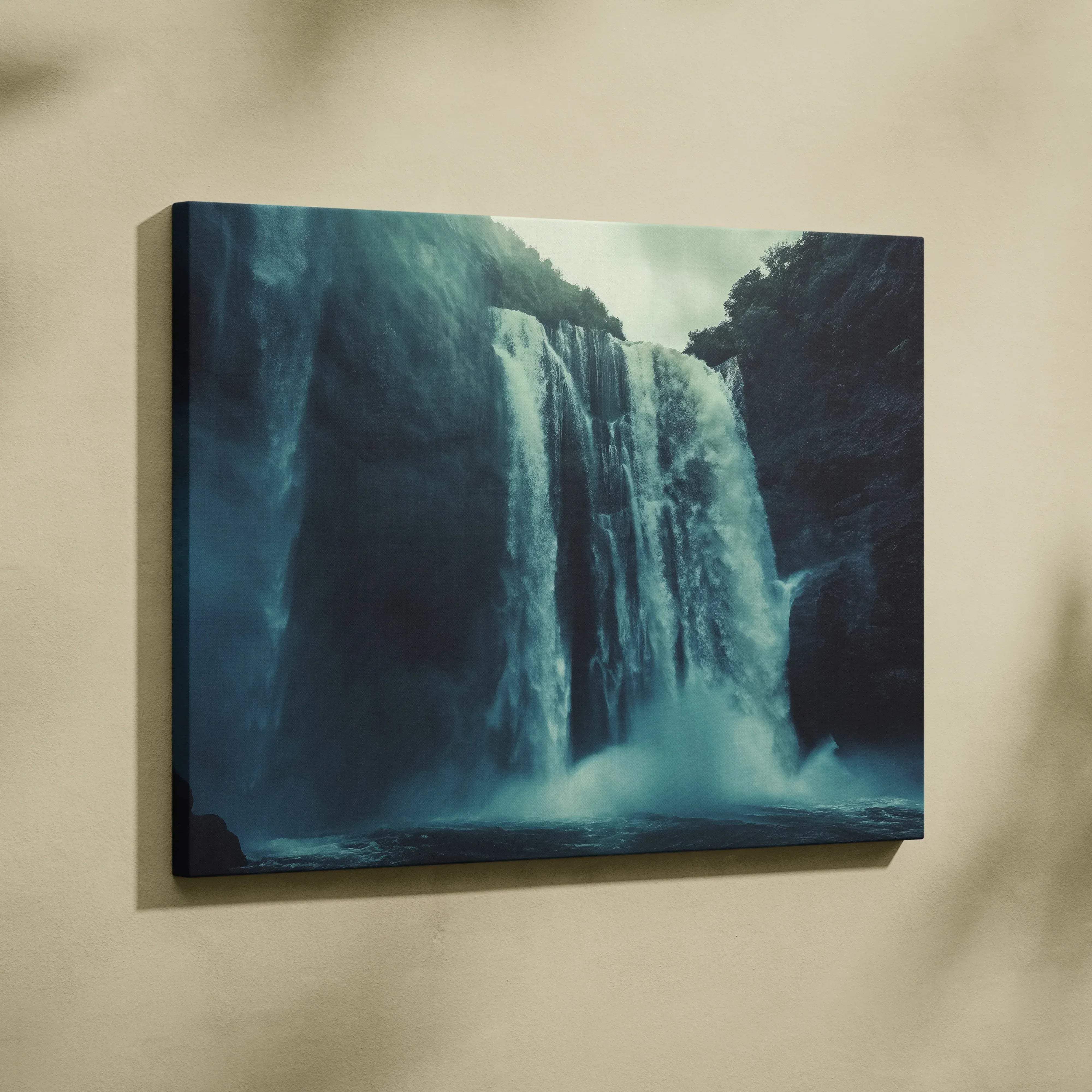 A canvas print of a dramatic waterfall in deep blues and whites mounted on a wall for modern home decor