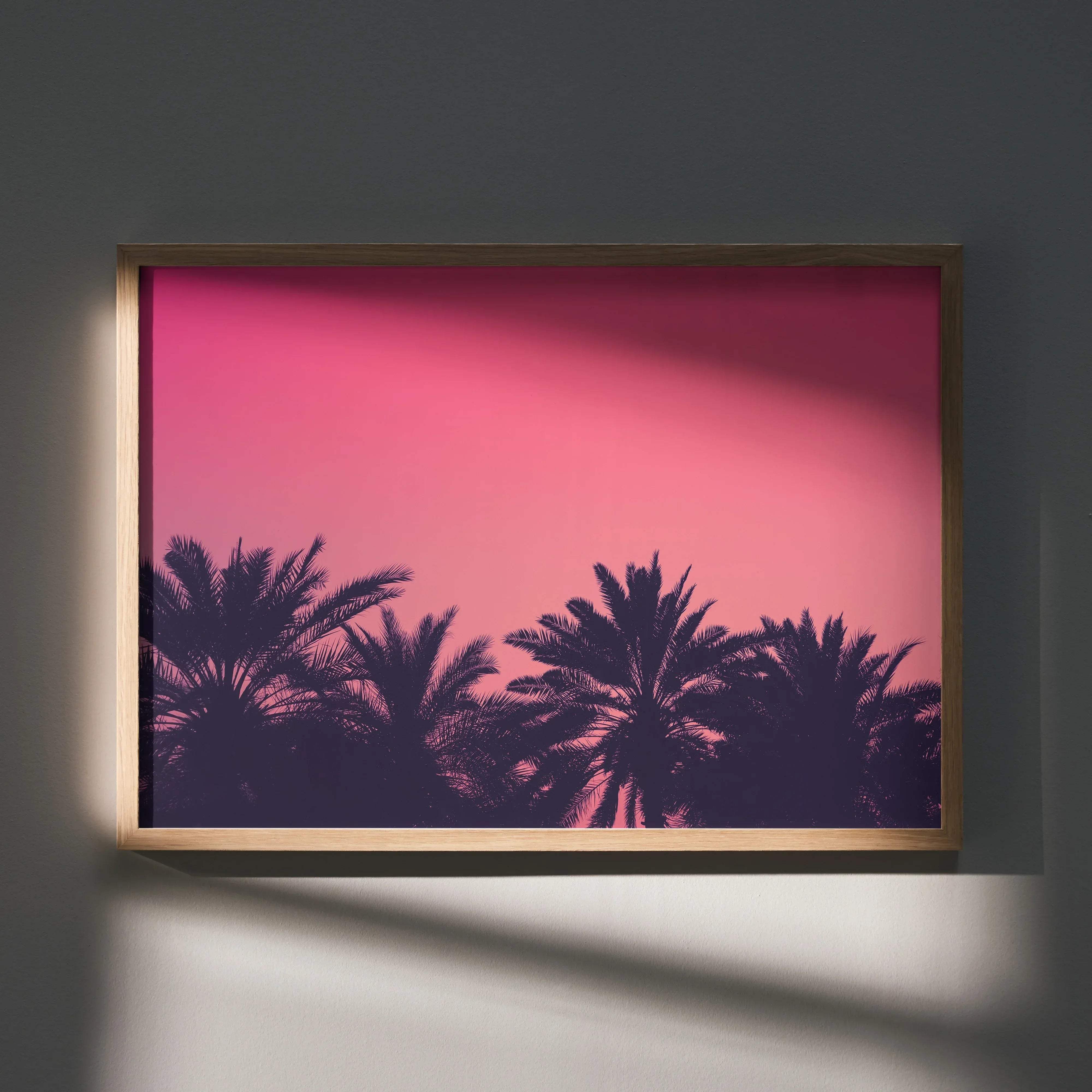A serene beach digital art poster featuring silhouetted palm trees against a vibrant pink sky in a gold frame
