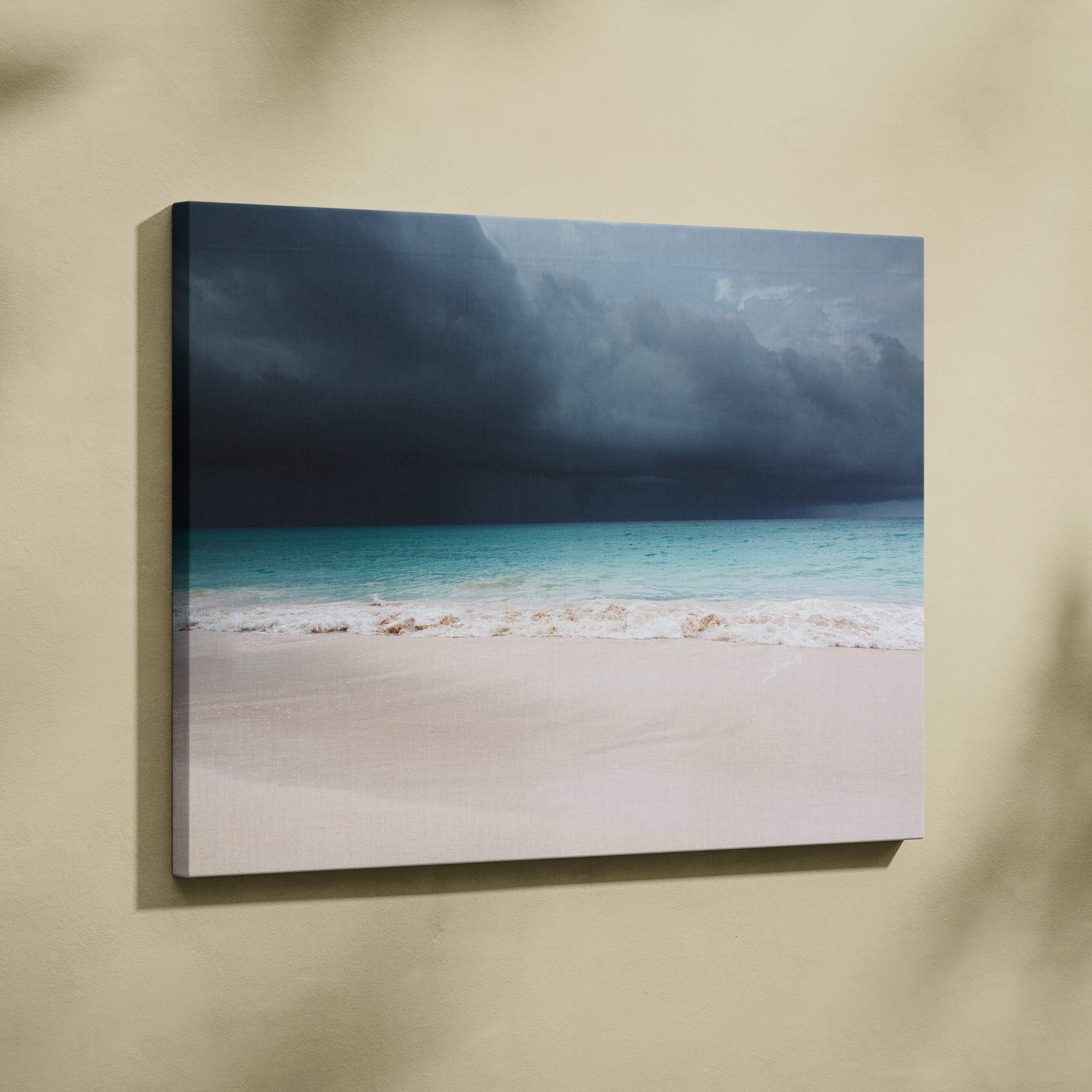 A framed canvas print of a stormy beach scene with turquoise waves white sand and dark thunderclouds wall decor
