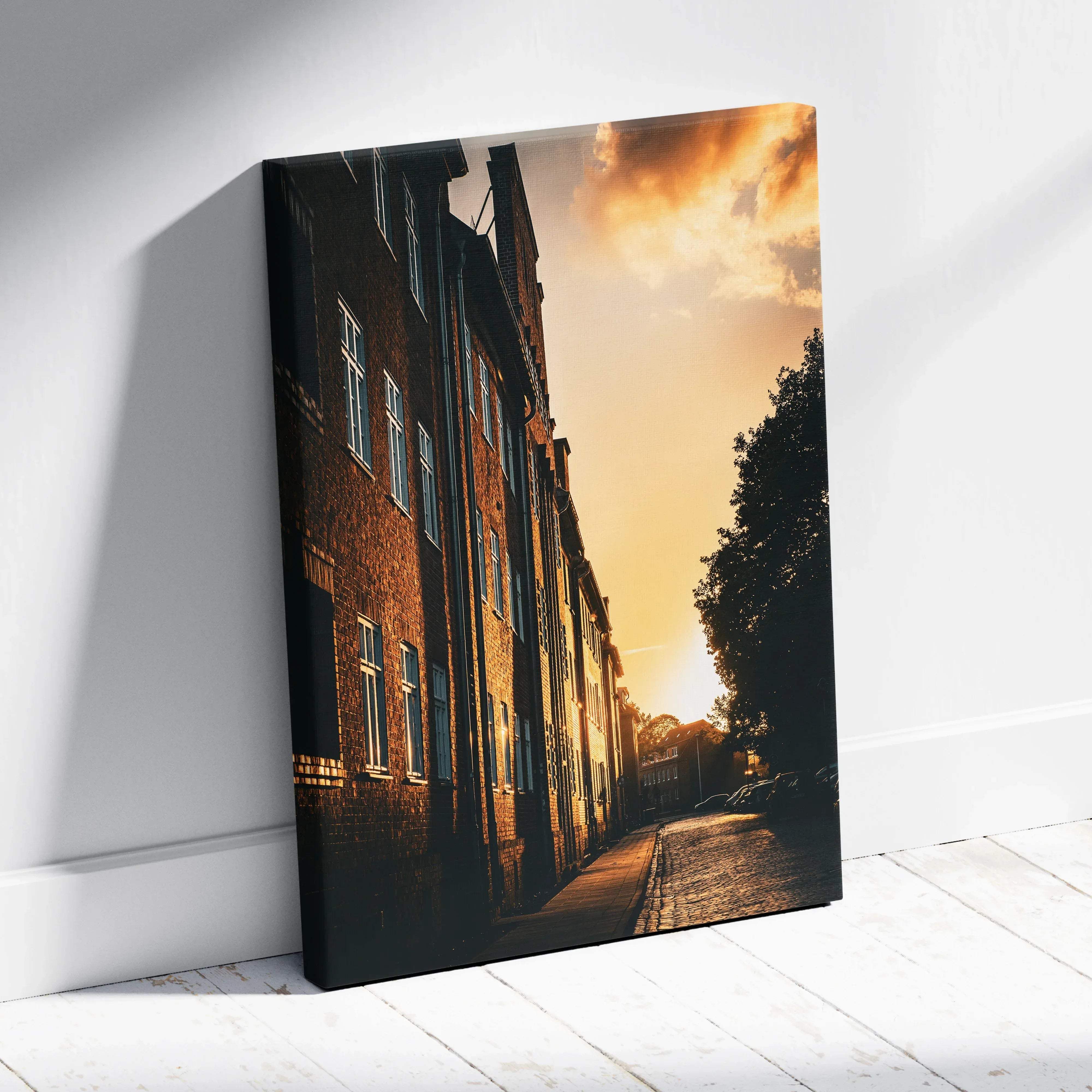 A rectangular canvas wall art featuring a warm-toned urban cityscape with brick buildings at golden hour sunset