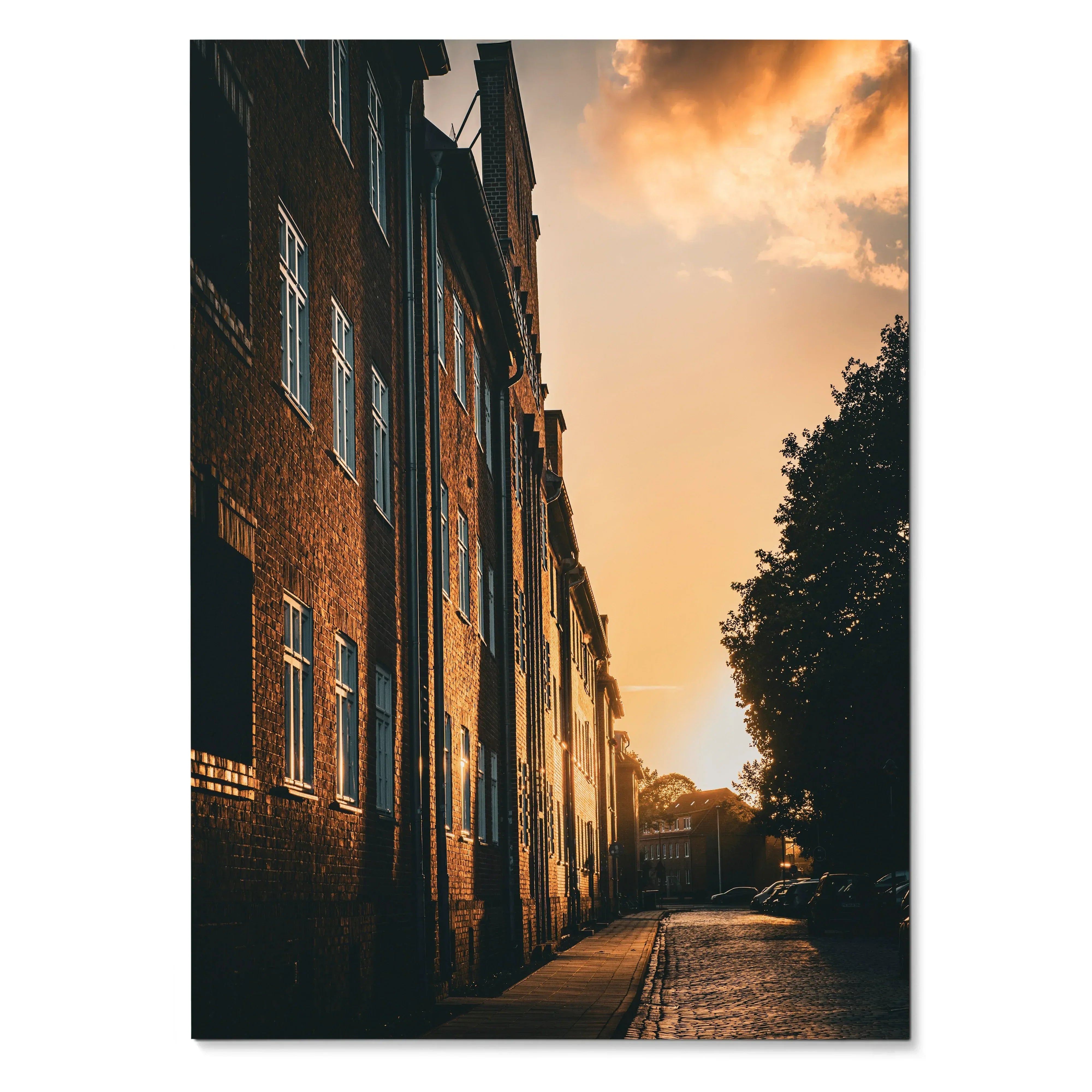 Vertical wall art poster of brick city buildings glowing under a vibrant sunset sky.
