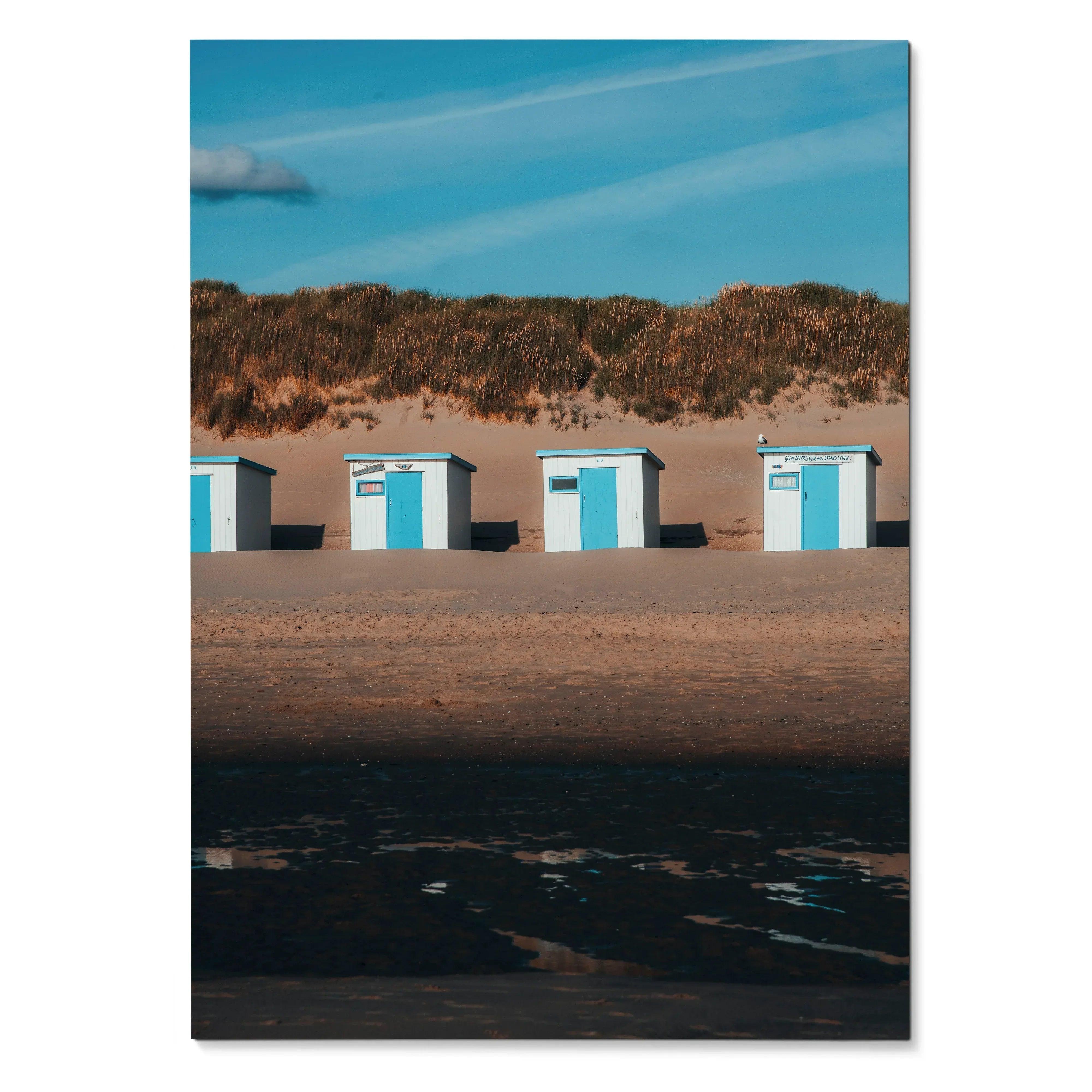 Serene beach landscape wall art poster showing four small blue and white beach huts under a blue sky.