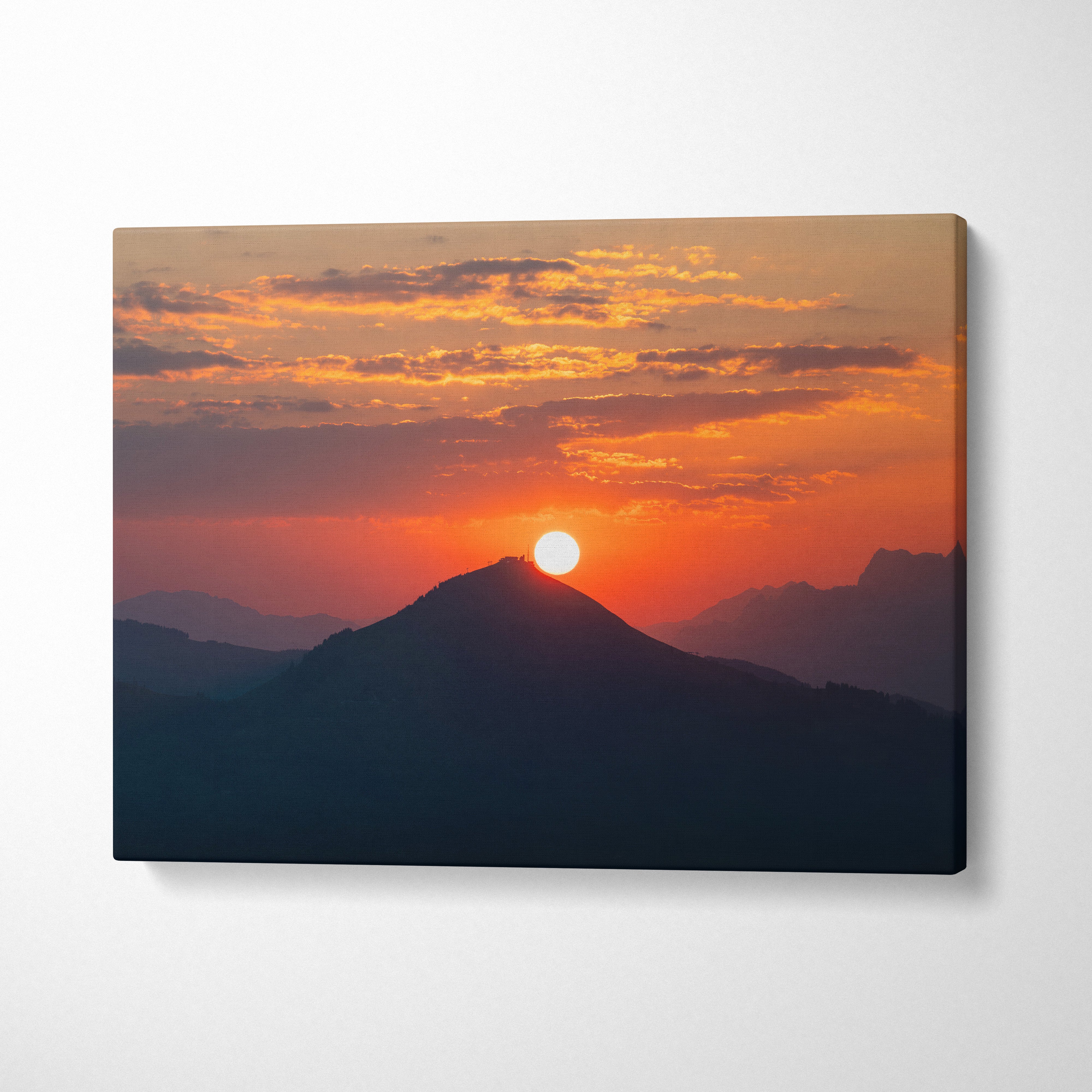 Canvas wall art featuring a vibrant mountain sunset with deep blue silhouettes and an orange sky.