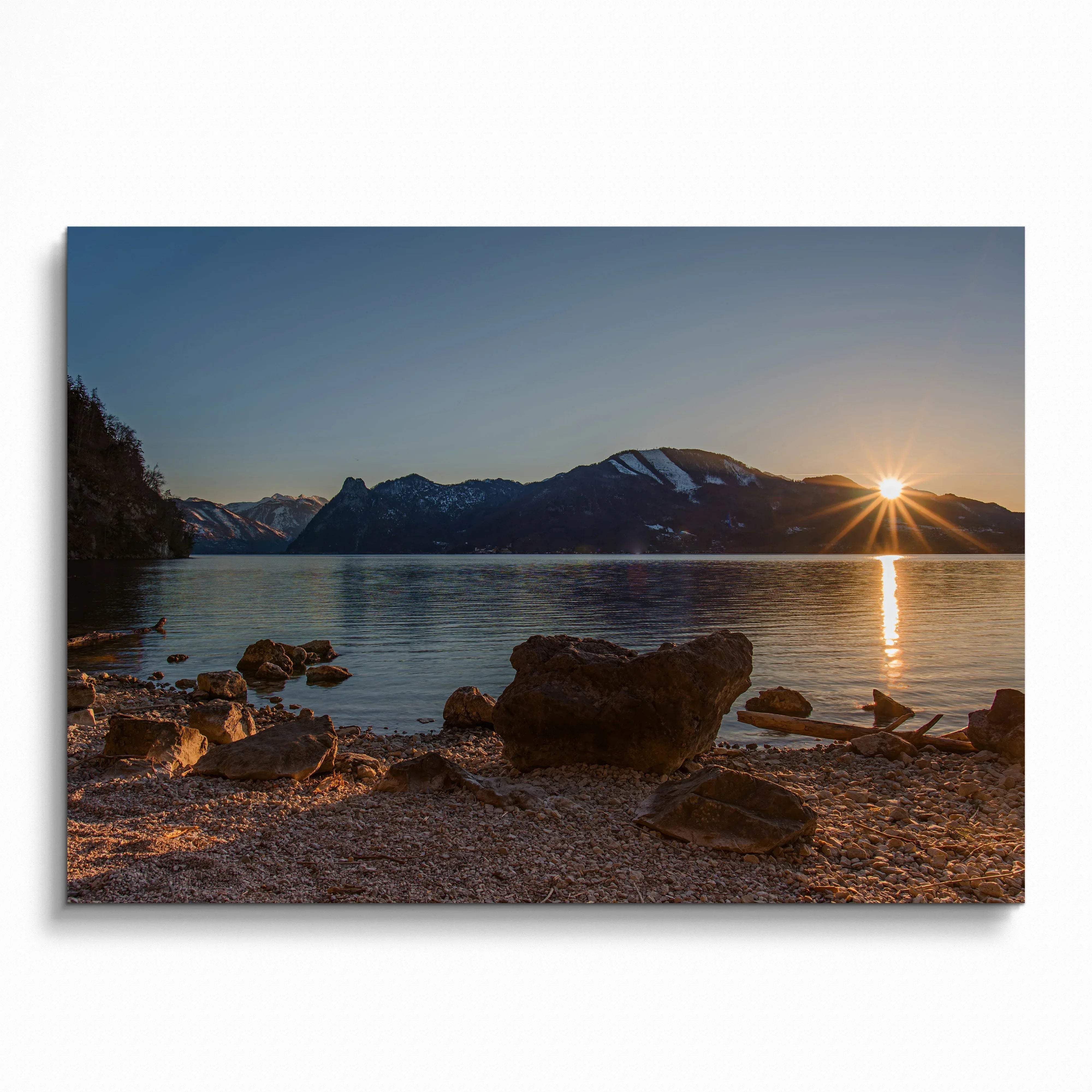 Majestic mountain sunset over calm lake with rocky shoreline, warm tones wall art poster.
