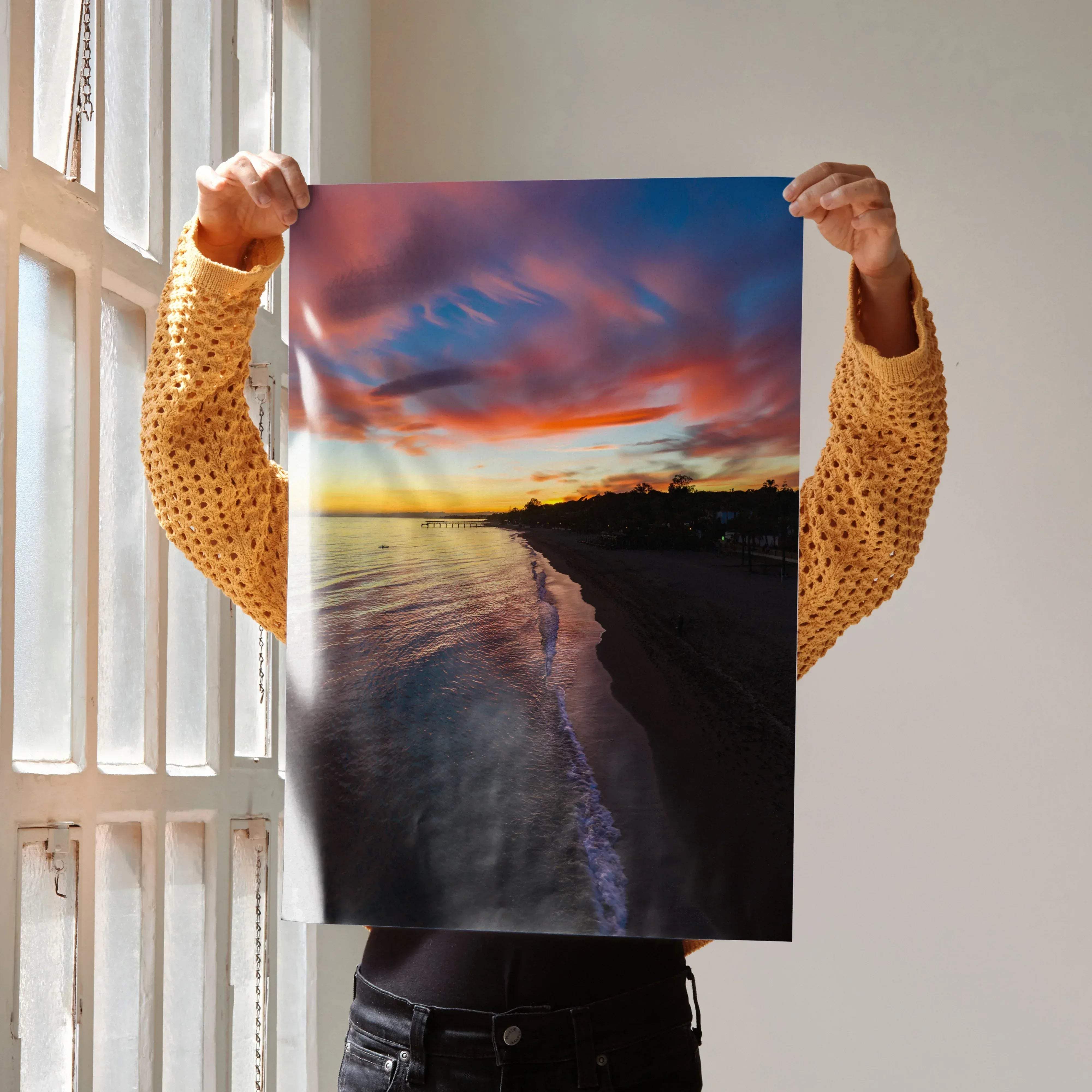 Vibrant beach sunset poster featuring a vertical design with swirling pink orange and blue clouds reflected in water