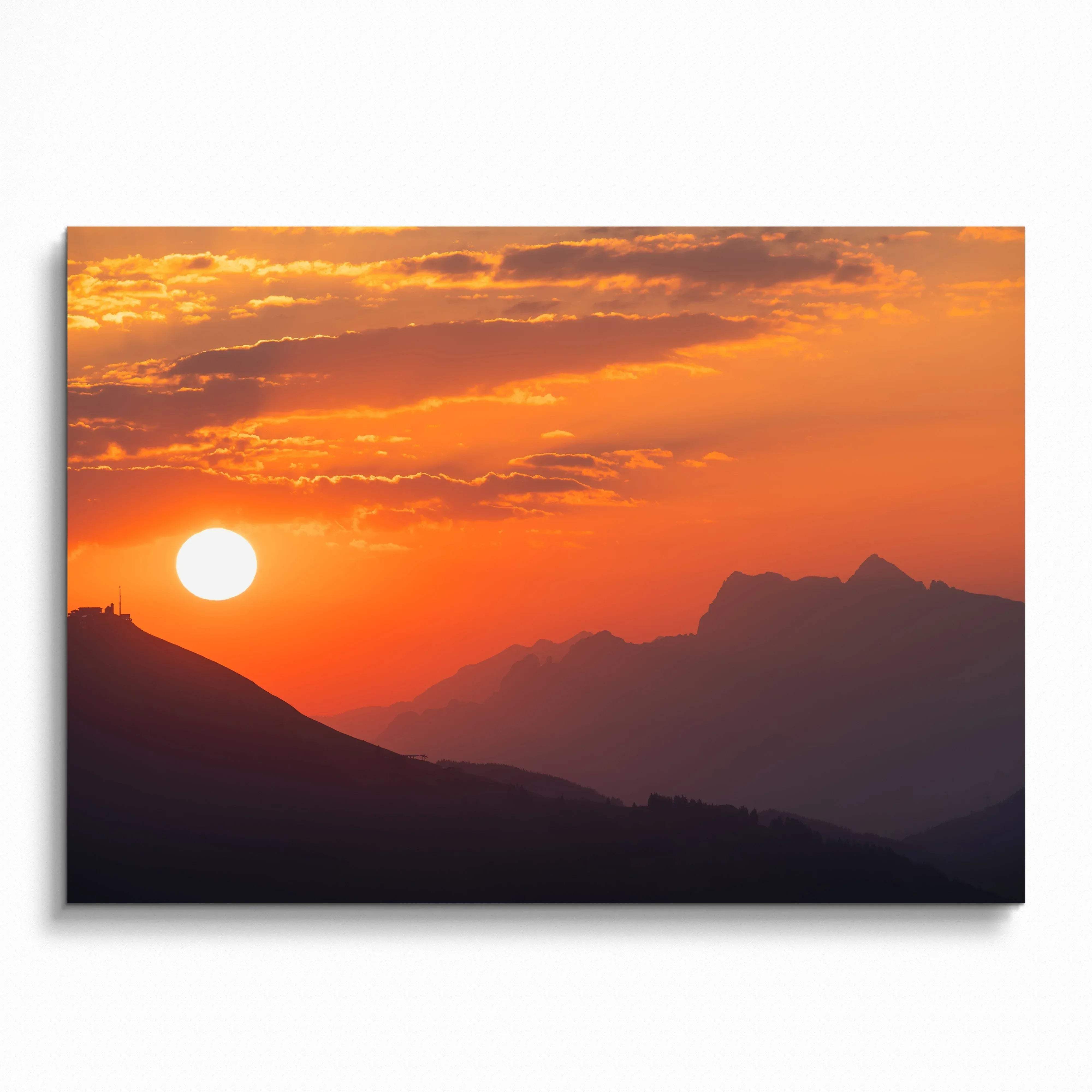 Sunset over layered mountain silhouettes in warm orange and purple tones wall art poster.