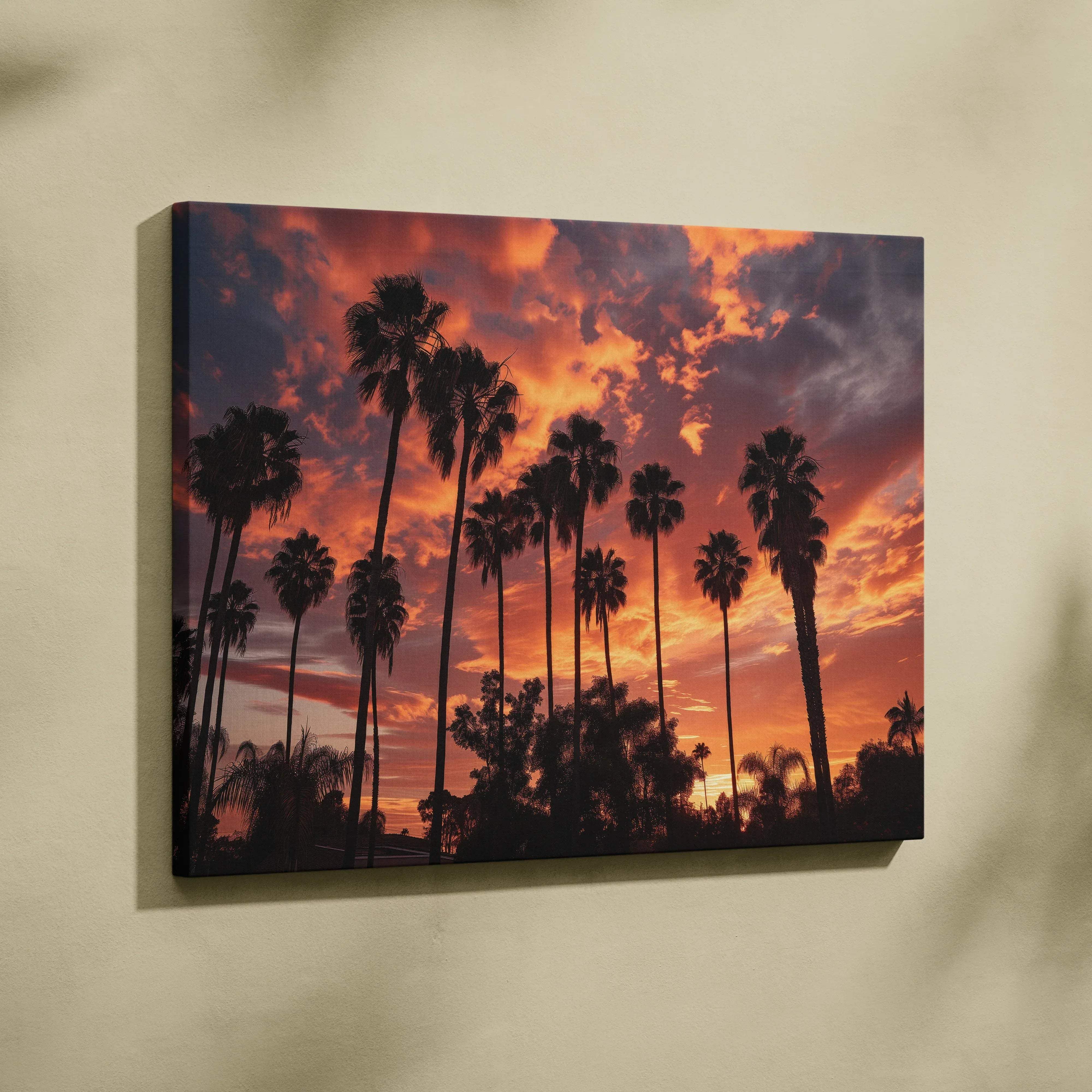 A rectangular canvas wall art featuring silhouetted palm trees against a vibrant orange and purple tropical sunset