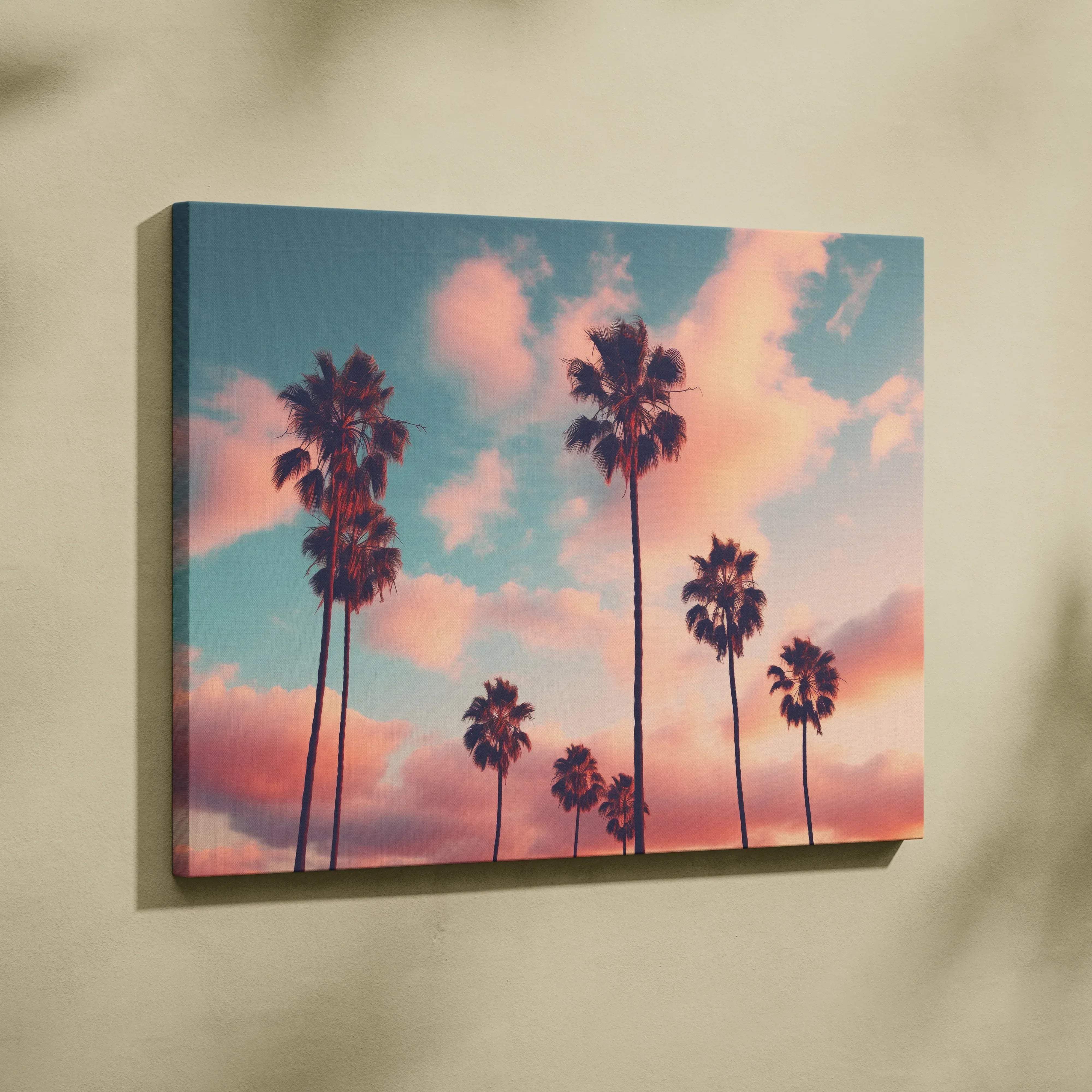 Rectangular canvas wall art featuring silhouetted palm trees against a warm coral sky with soft pink and teal clouds