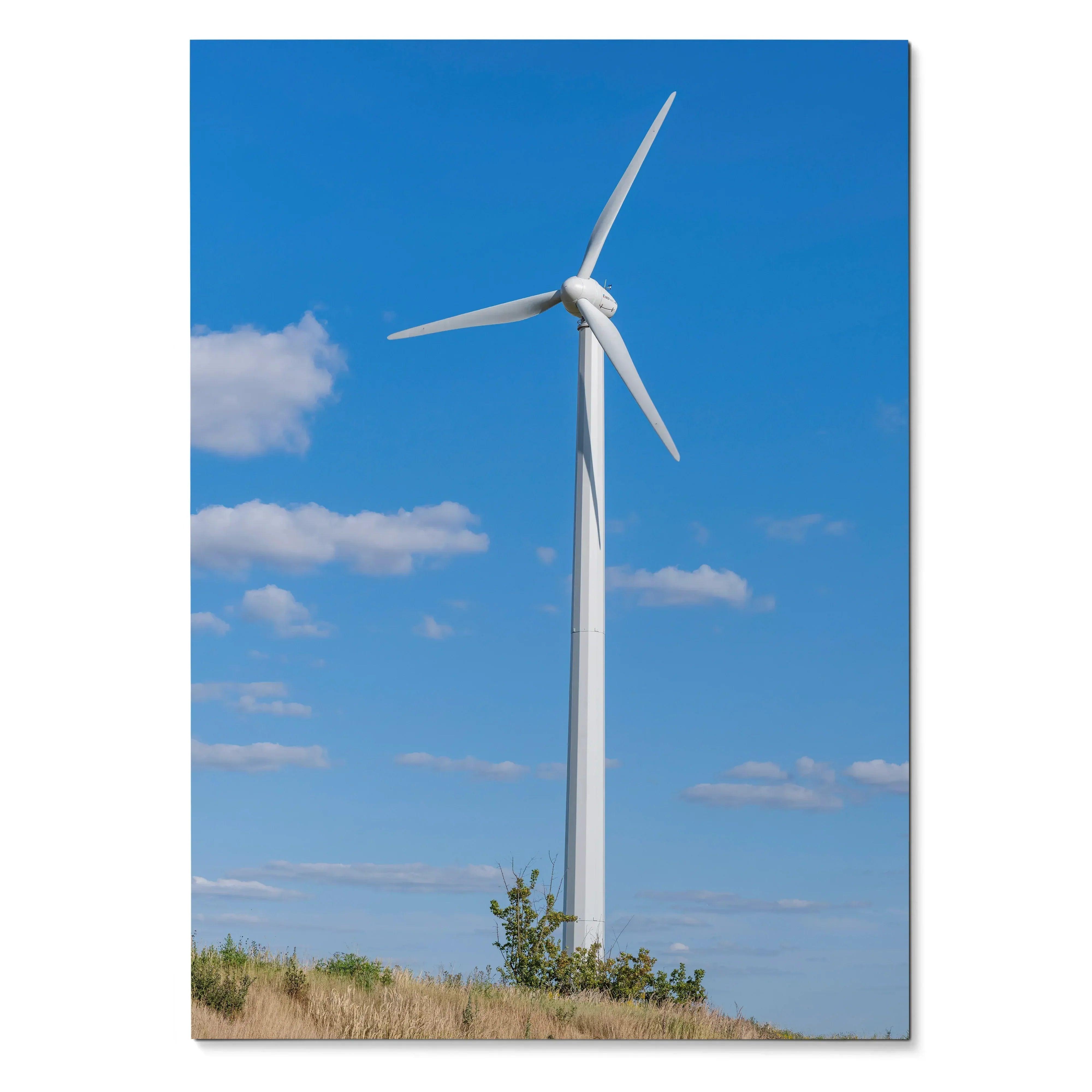 Vertical wall art poster of a white windmill against a blue sky with clouds in a rural landscape.