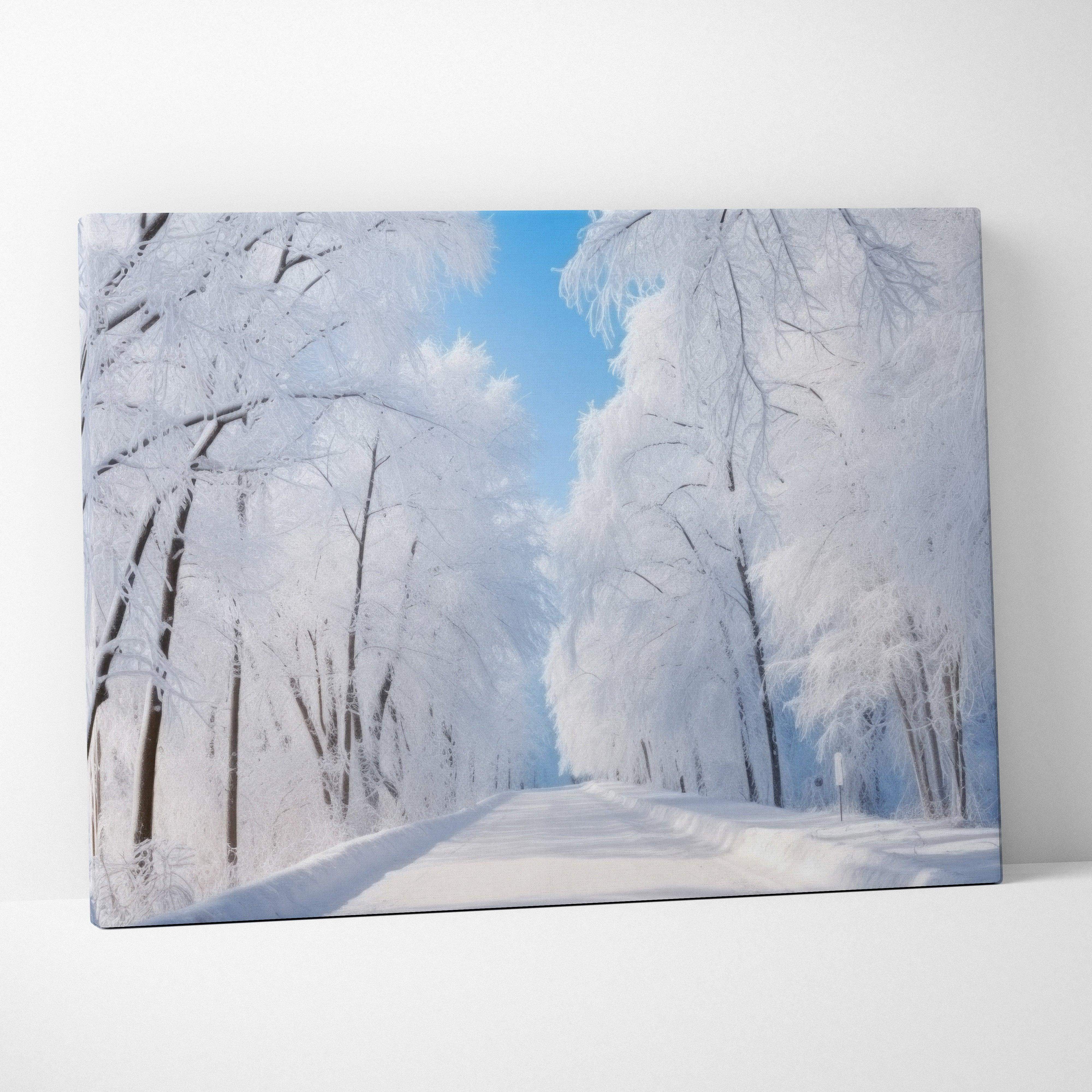 Dreamy winter landscape canvas wall art featuring a snow-covered tree-lined road with frosted blue trees
