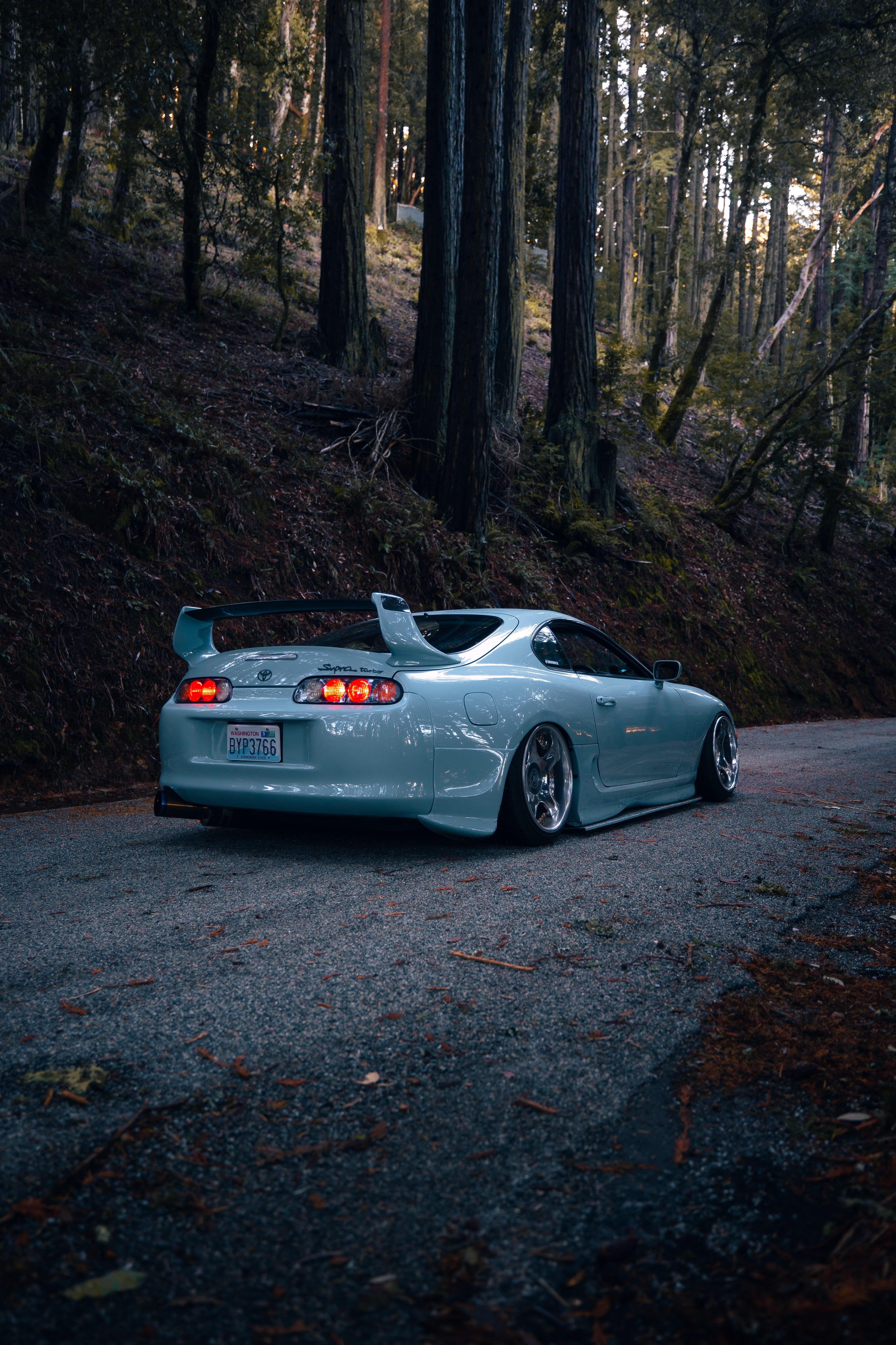 Sleek light blue Toyota Supra Mk4 with lowered stance and aftermarket wheels