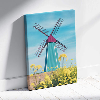 Vibrant teal magenta windmill canvas art over yellow flowers blue sky