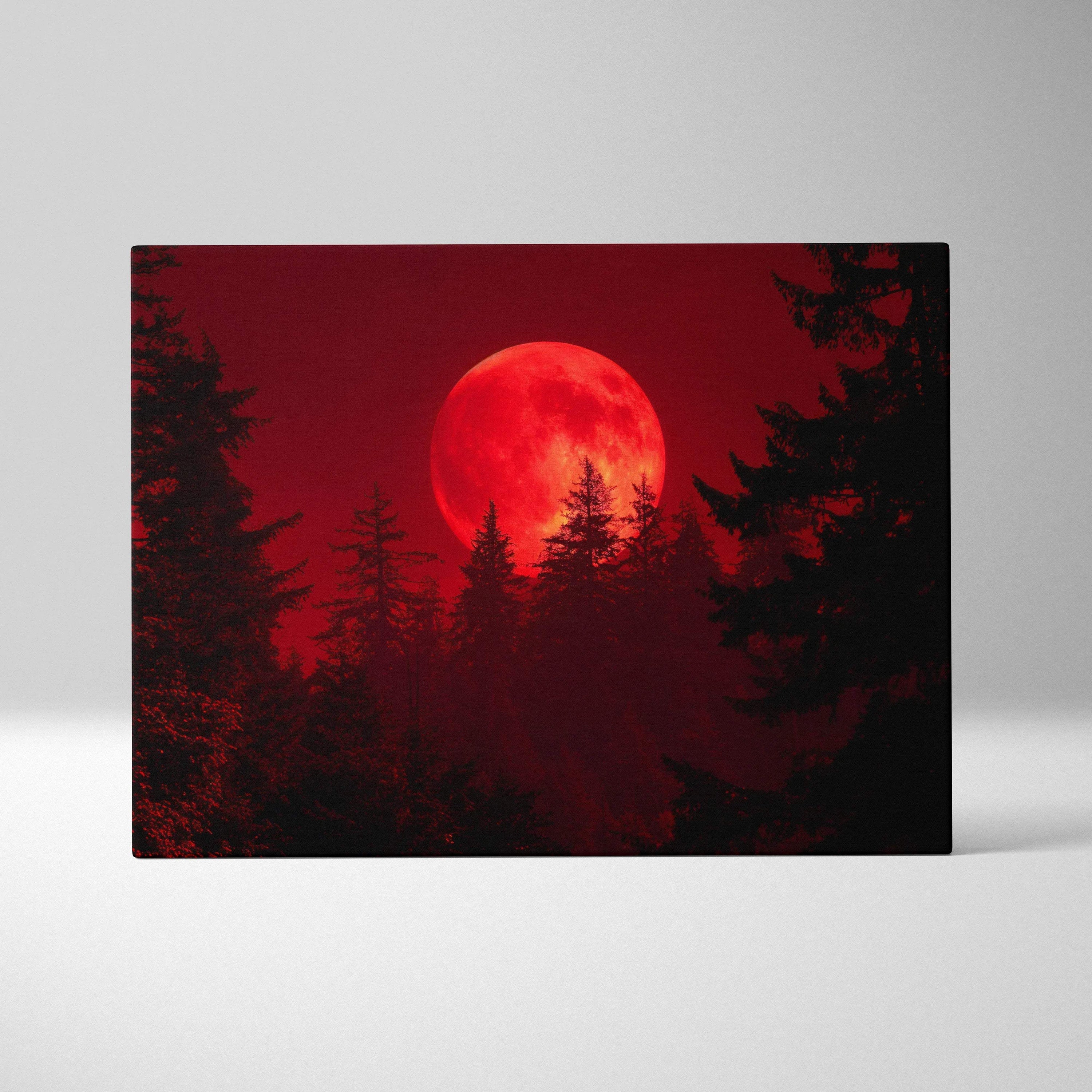 Blood red moon rising over silhouetted pine trees canvas print