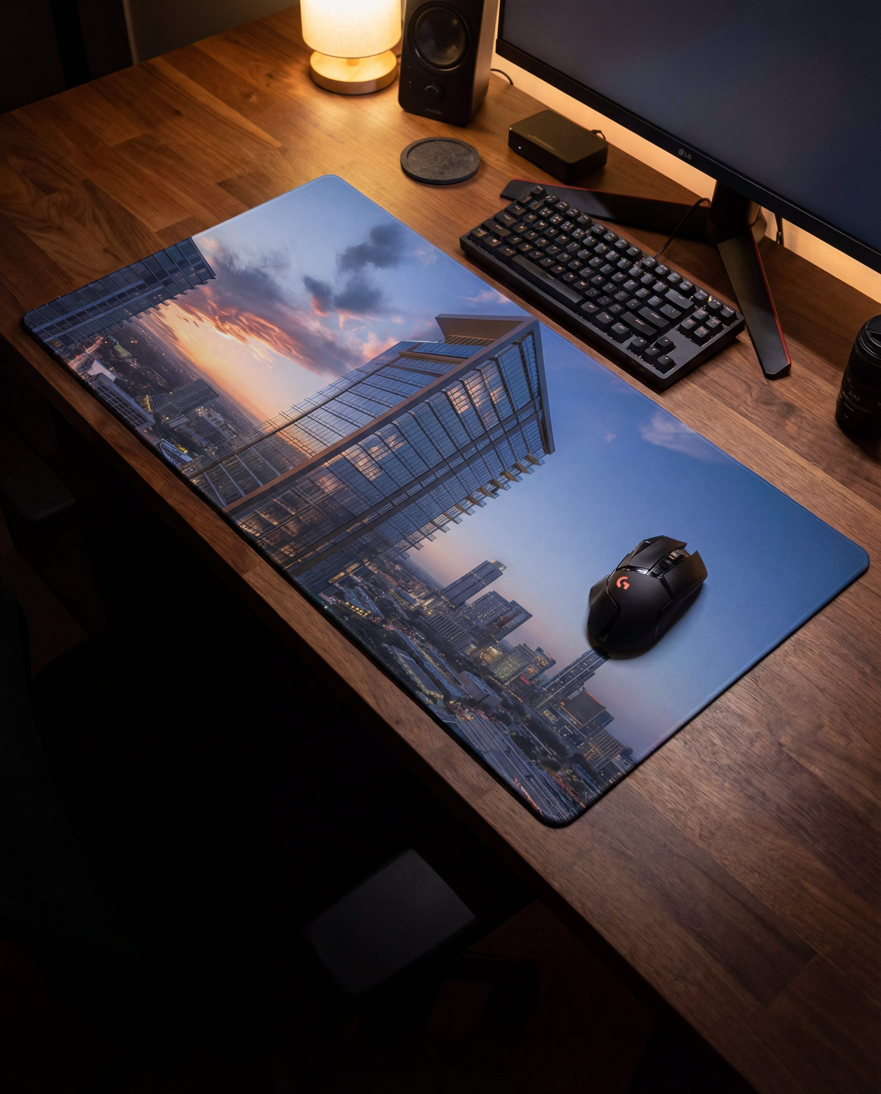 A rectangular gaming mousepad featuring a vibrant cityscape at sunset with modern glass buildings, printed on smooth, non-slip surface.