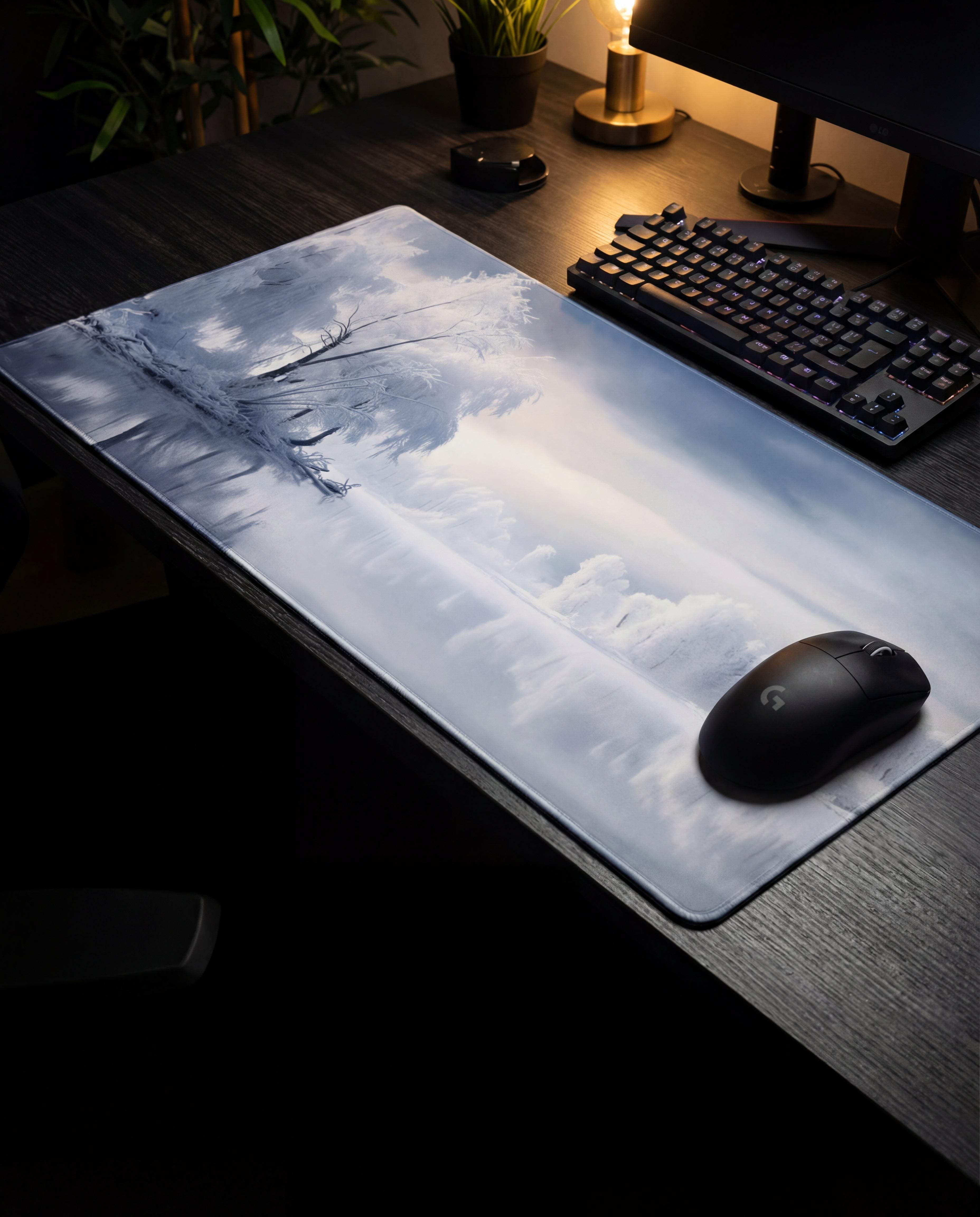 A sleek, rectangular gaming mousepad featuring a detailed grayscale landscape of bare trees against a misty sky.