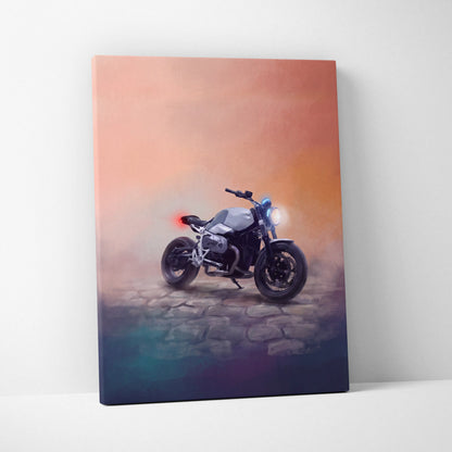 Canvas print of a sleek silver and black bmw r ninet inspired naked motorcycle with glowing headlights and sunset backdrop