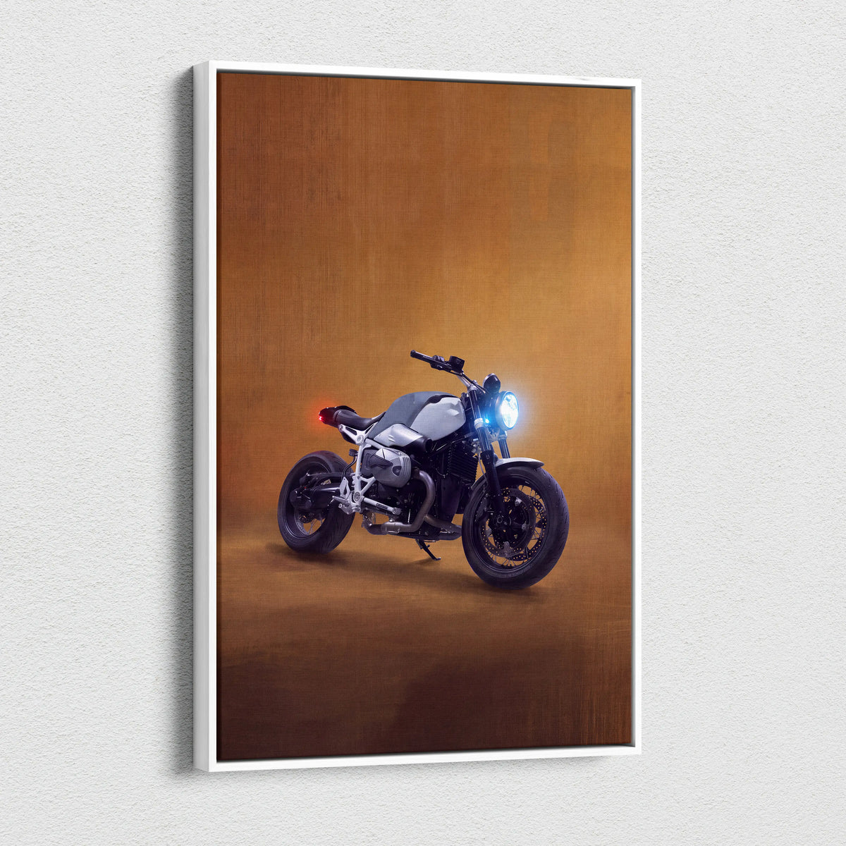 A sleek silver and black BMW R nineT inspired motorcycle canvas print with glowing headlights and warm amber backdrop
