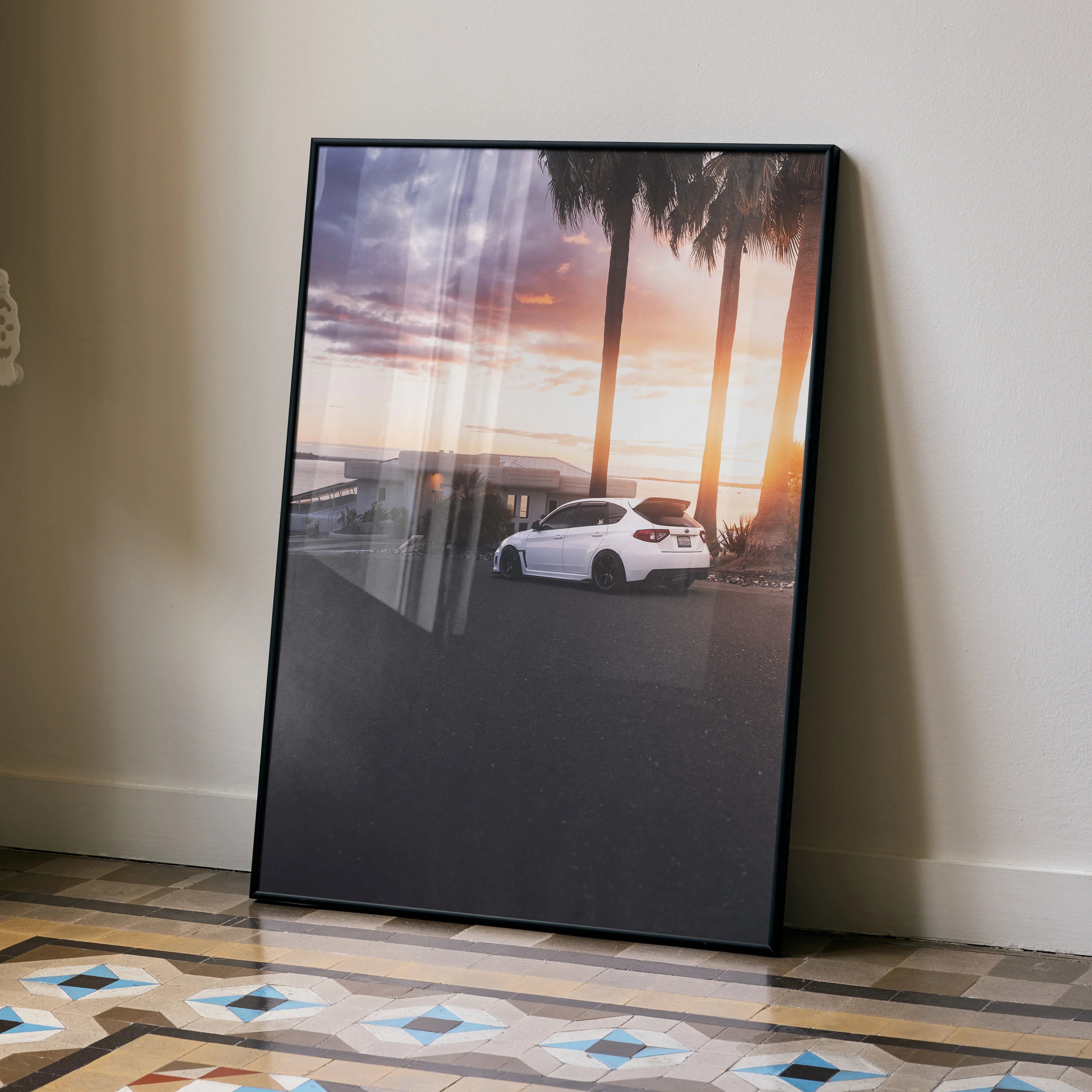 Subaru WRX STI parked under palm trees at sunset poster wall art with vibrant sky colors.