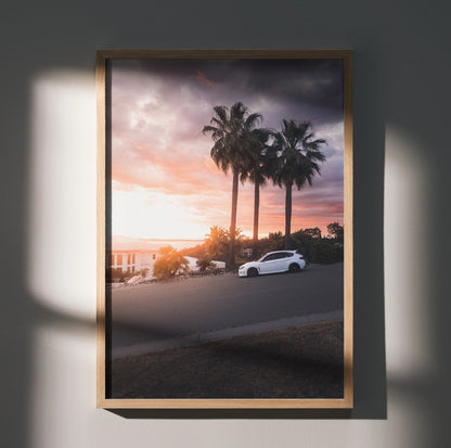 Subaru WRX STI driving on coastal road at sunset with palm trees poster wall art.