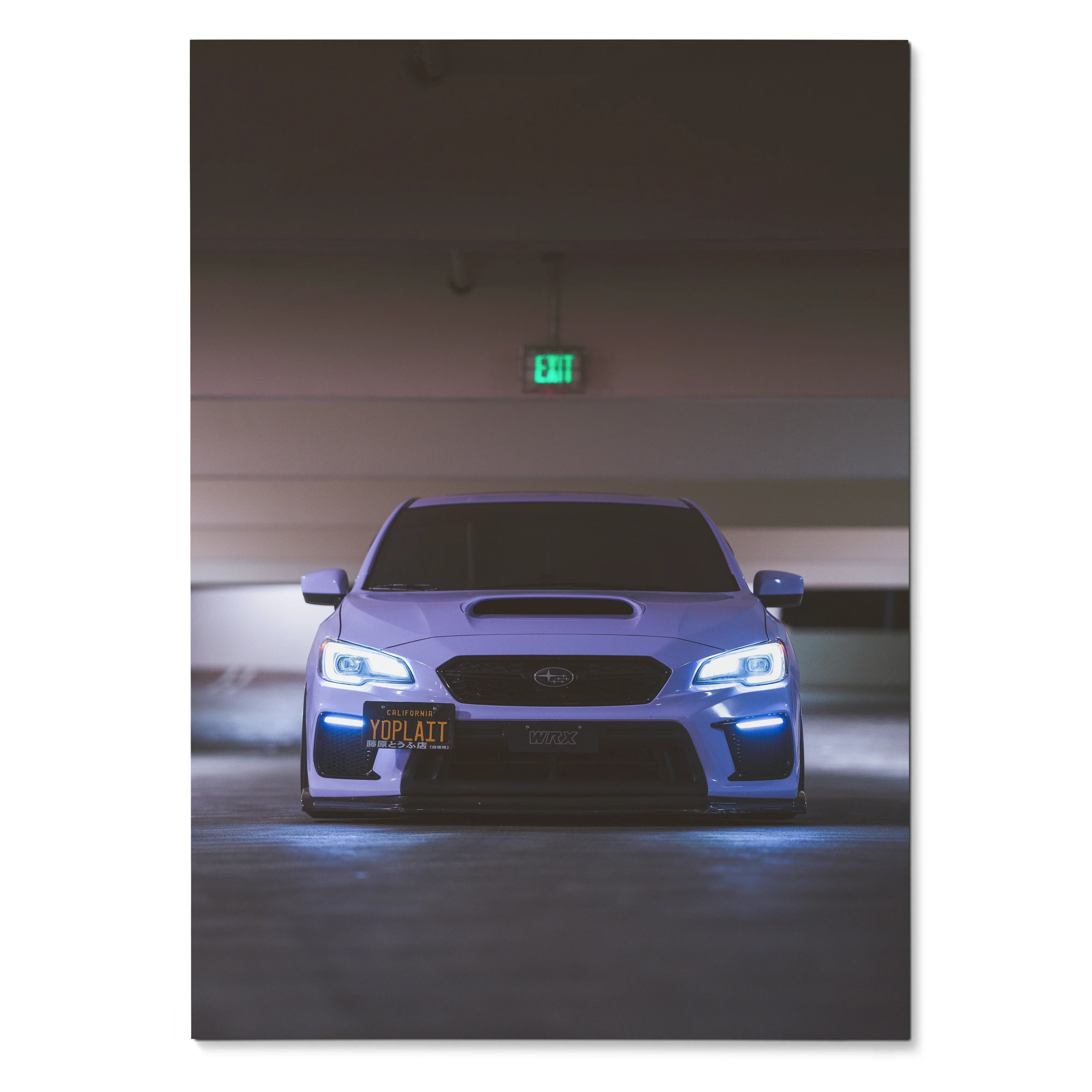 Subaru WRX front view with illuminated headlights poster wall art in dark garage setting.