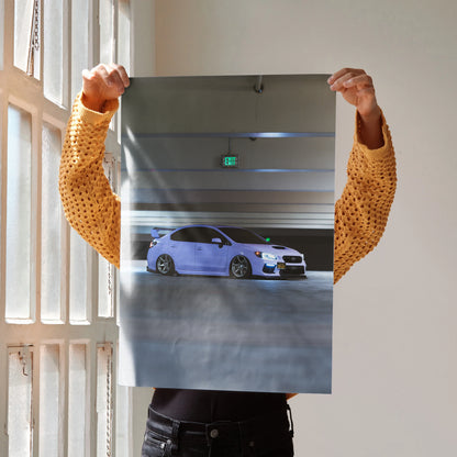 Subaru WRX blue sports car poster held against wall, premium automotive wall art.