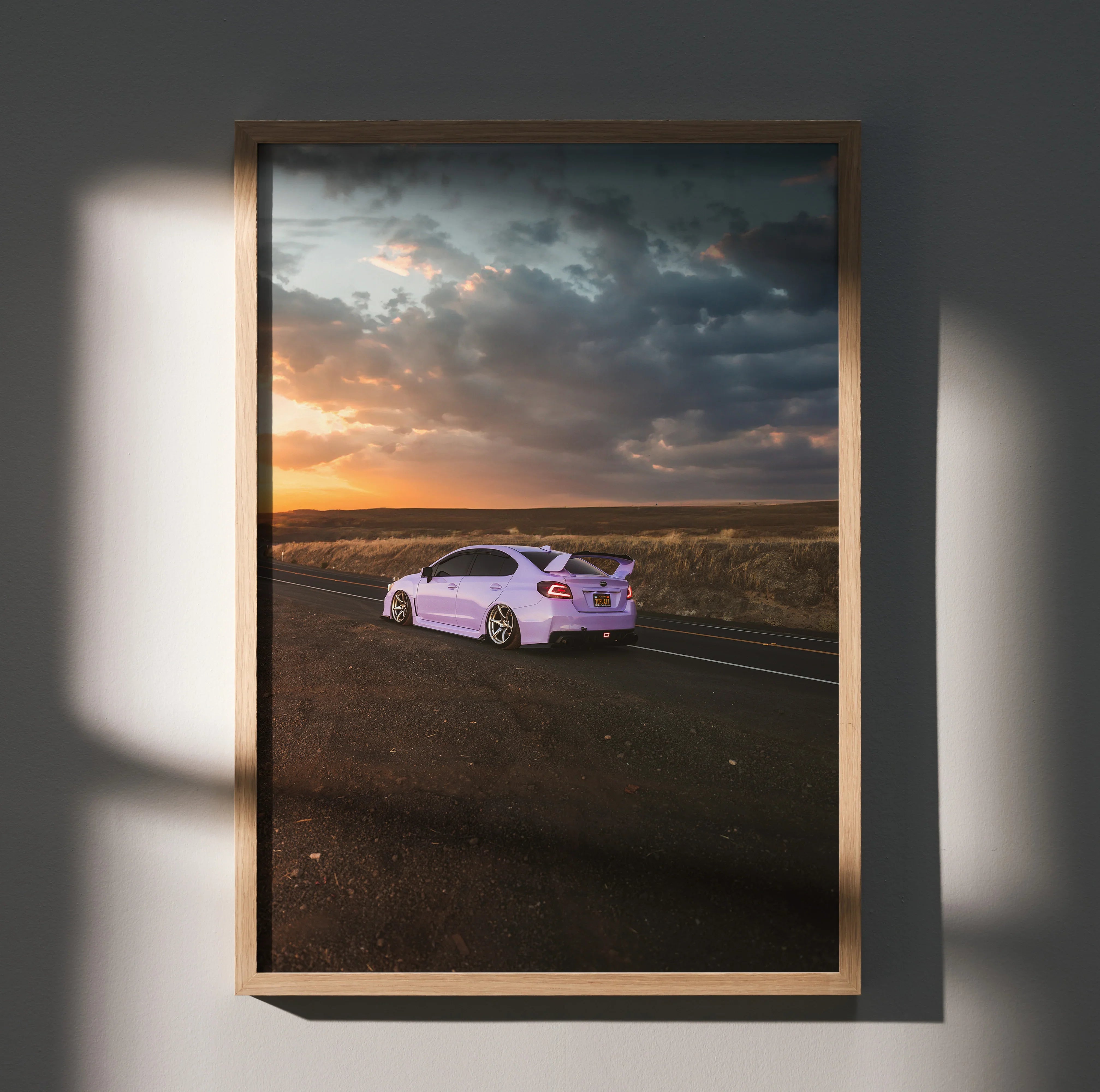 Subaru WRX on open road at sunset poster wall art with dramatic clouds and warm light.