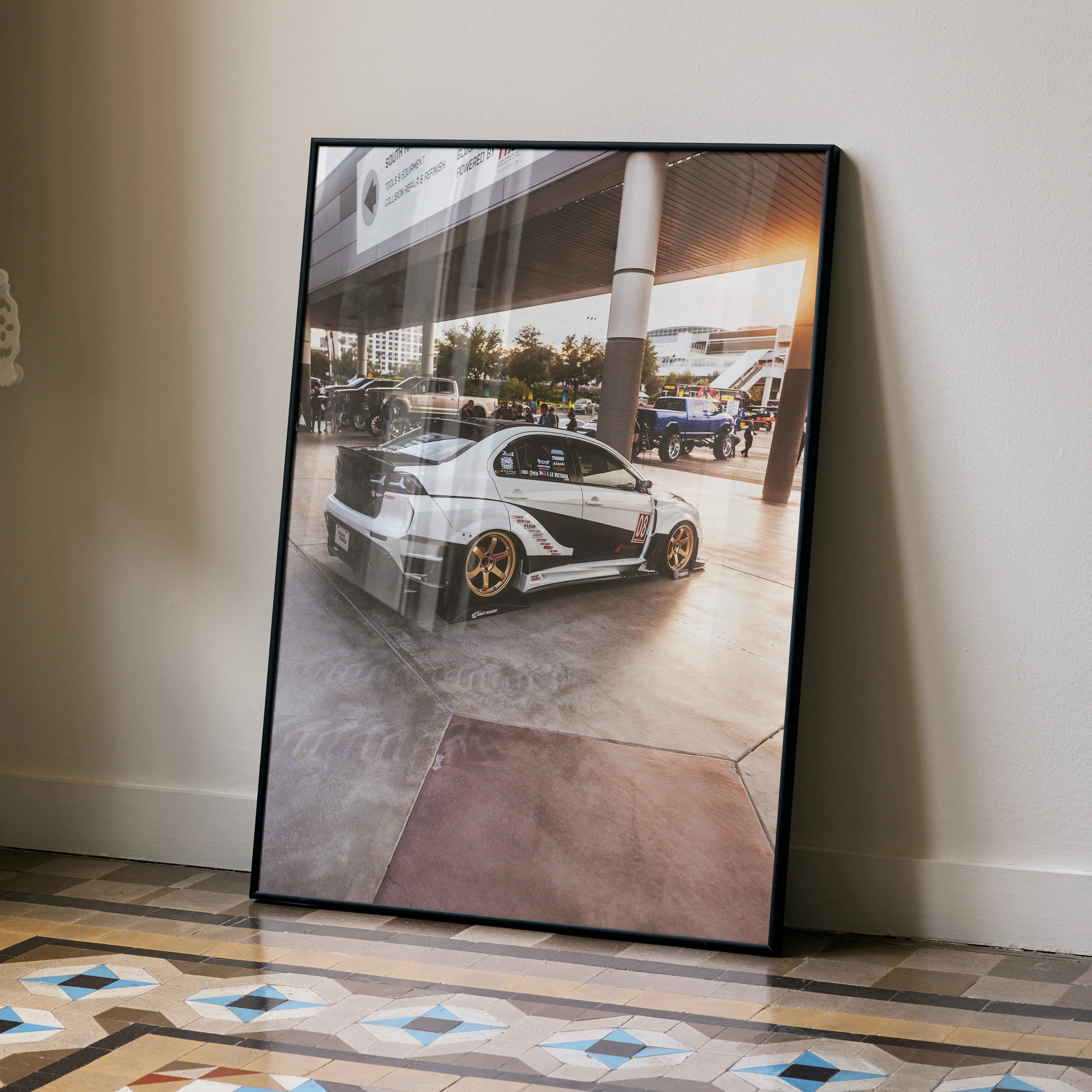 Mitsubishi Evo 10 poster wall art showing silver sports car with gold wheels in a modern garage setting.