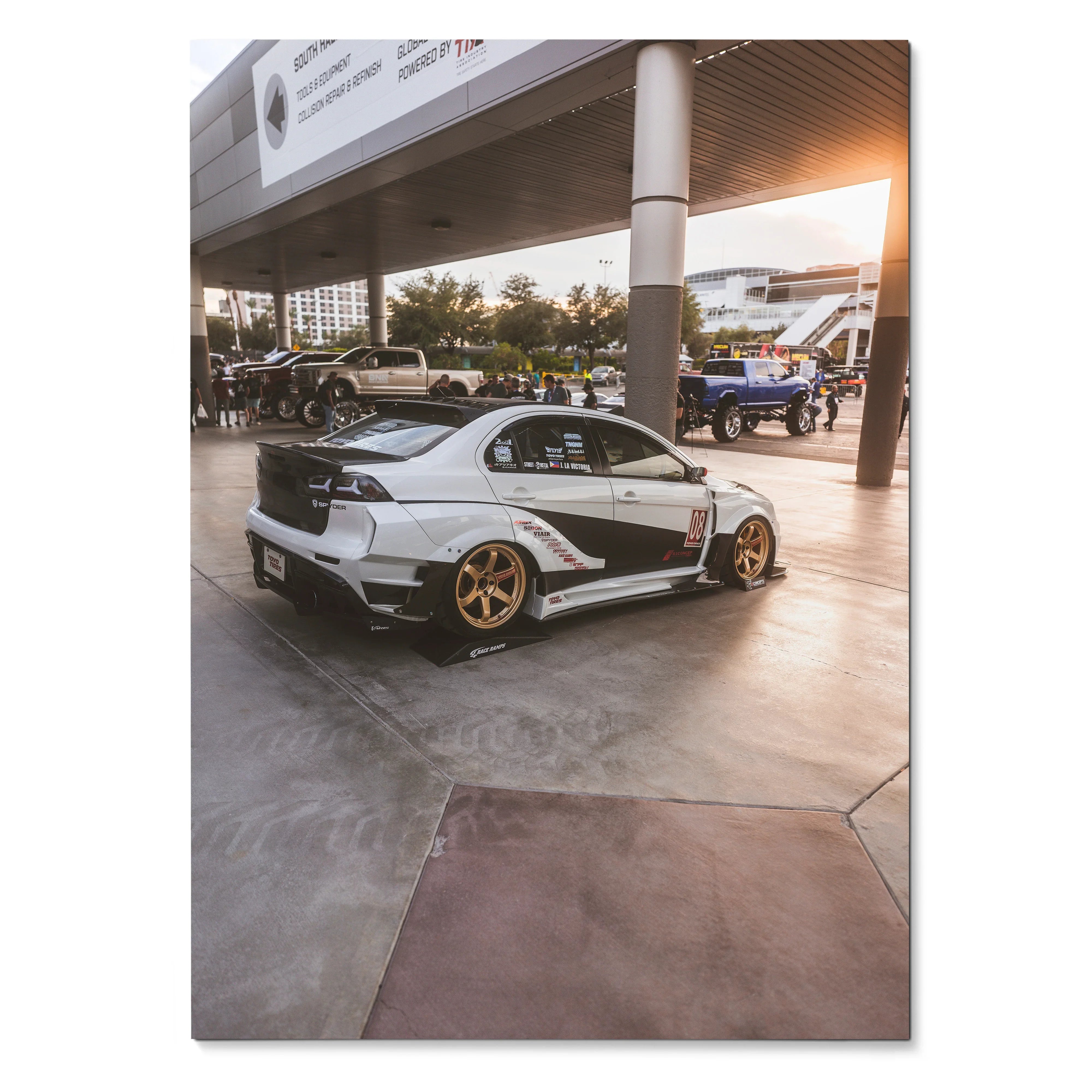 Mitsubishi Evo 10 with gold wheels and black racing decals in outdoor car show poster wall art.