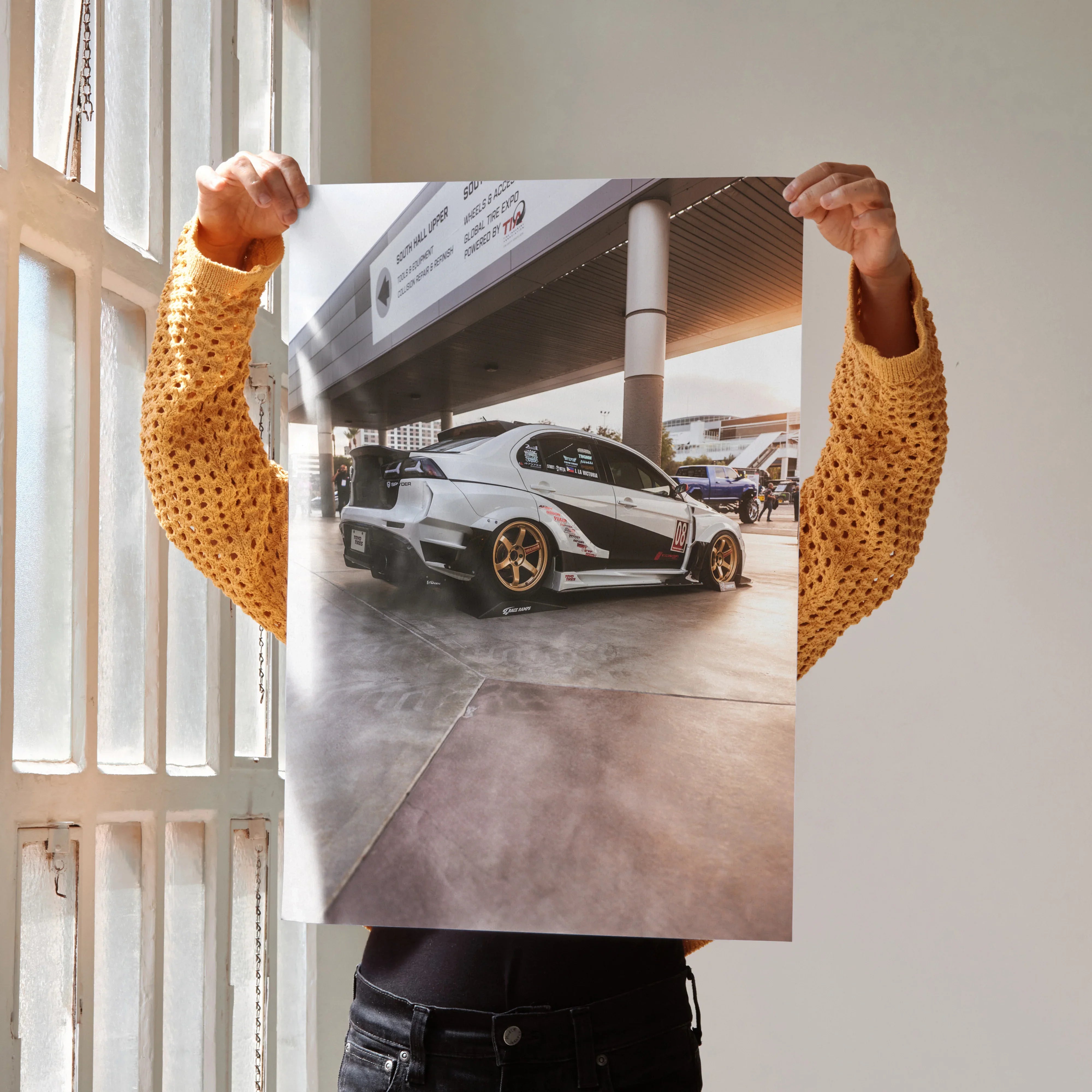 Mitsubishi Evo 10 poster with sleek silver car, gold rims, and urban background wall art.