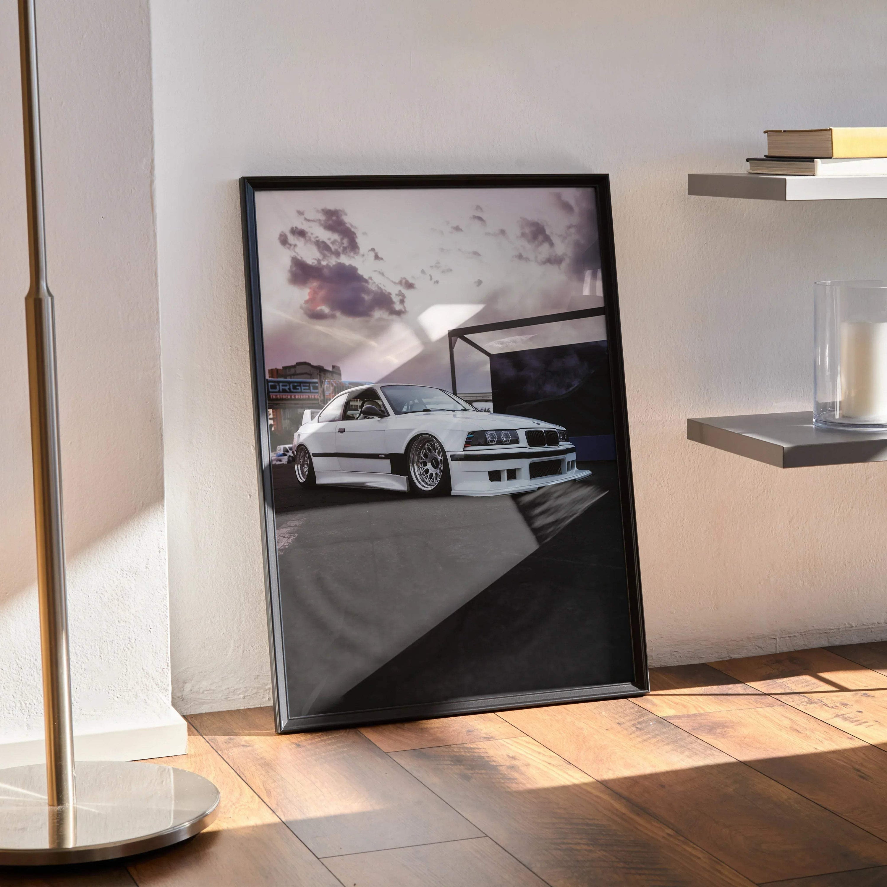 BMW E36 M3 poster in black frame leaning against wall, iconic white sports car with dramatic sky wall art.