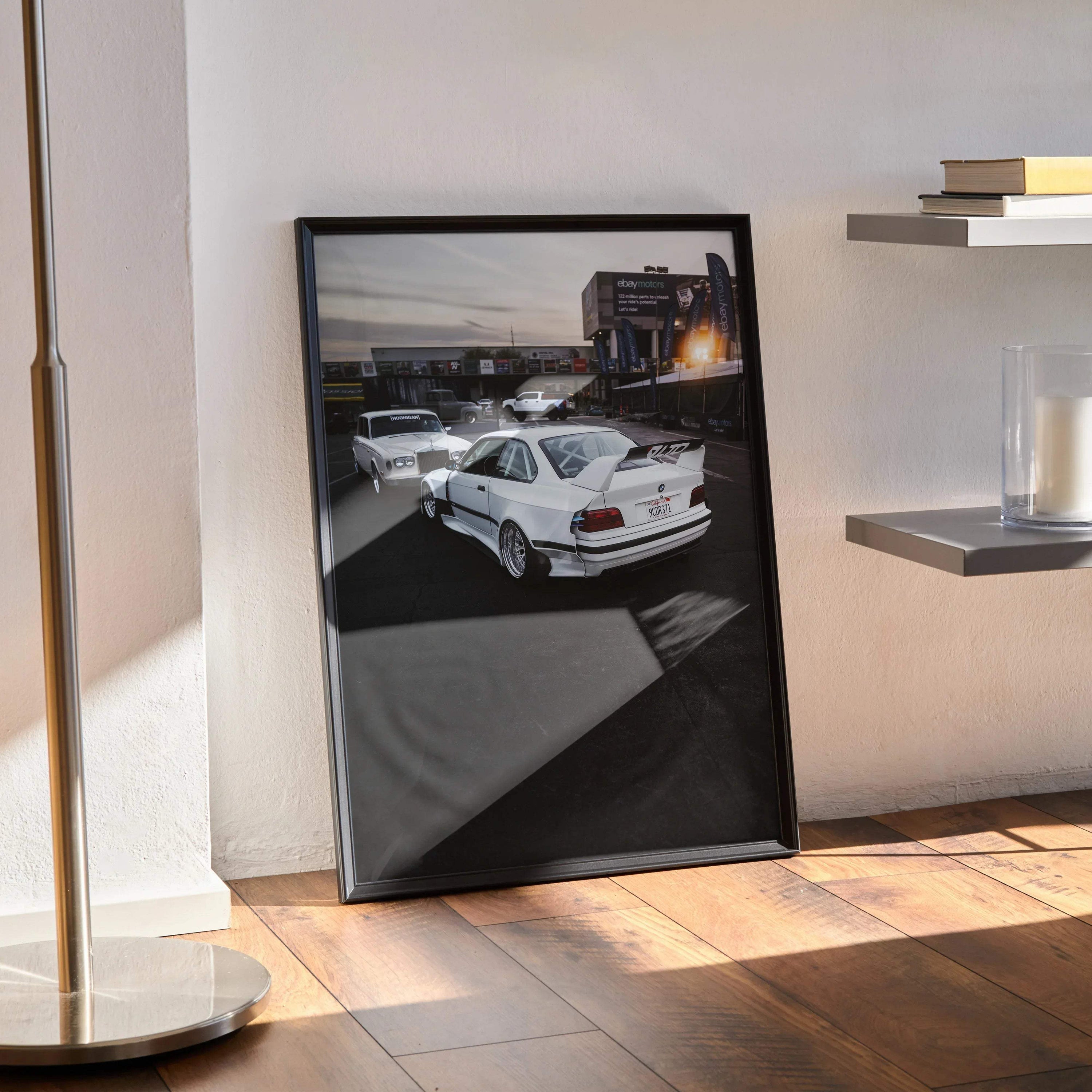 BMW E36 M3 white sports car poster leaning against wall, modern automotive wall art in black frame.