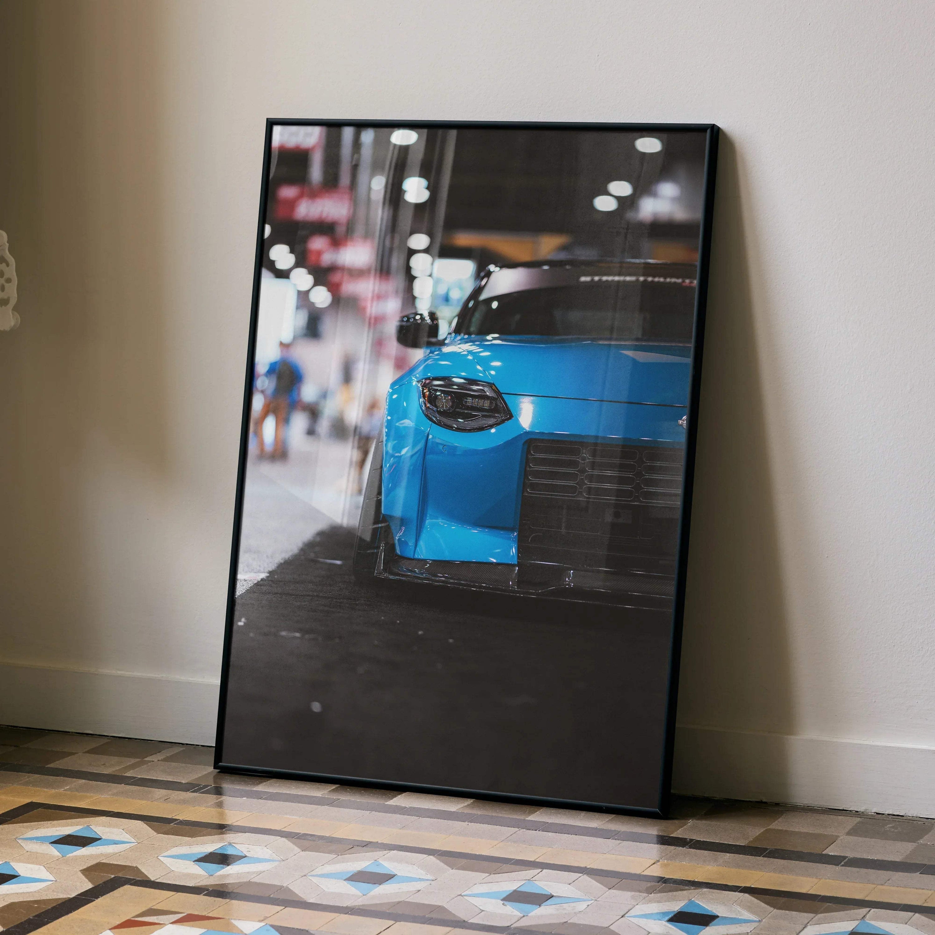 Nissan Z (RZ34) blue sports car close-up poster framed as automotive wall art leaning on floor.