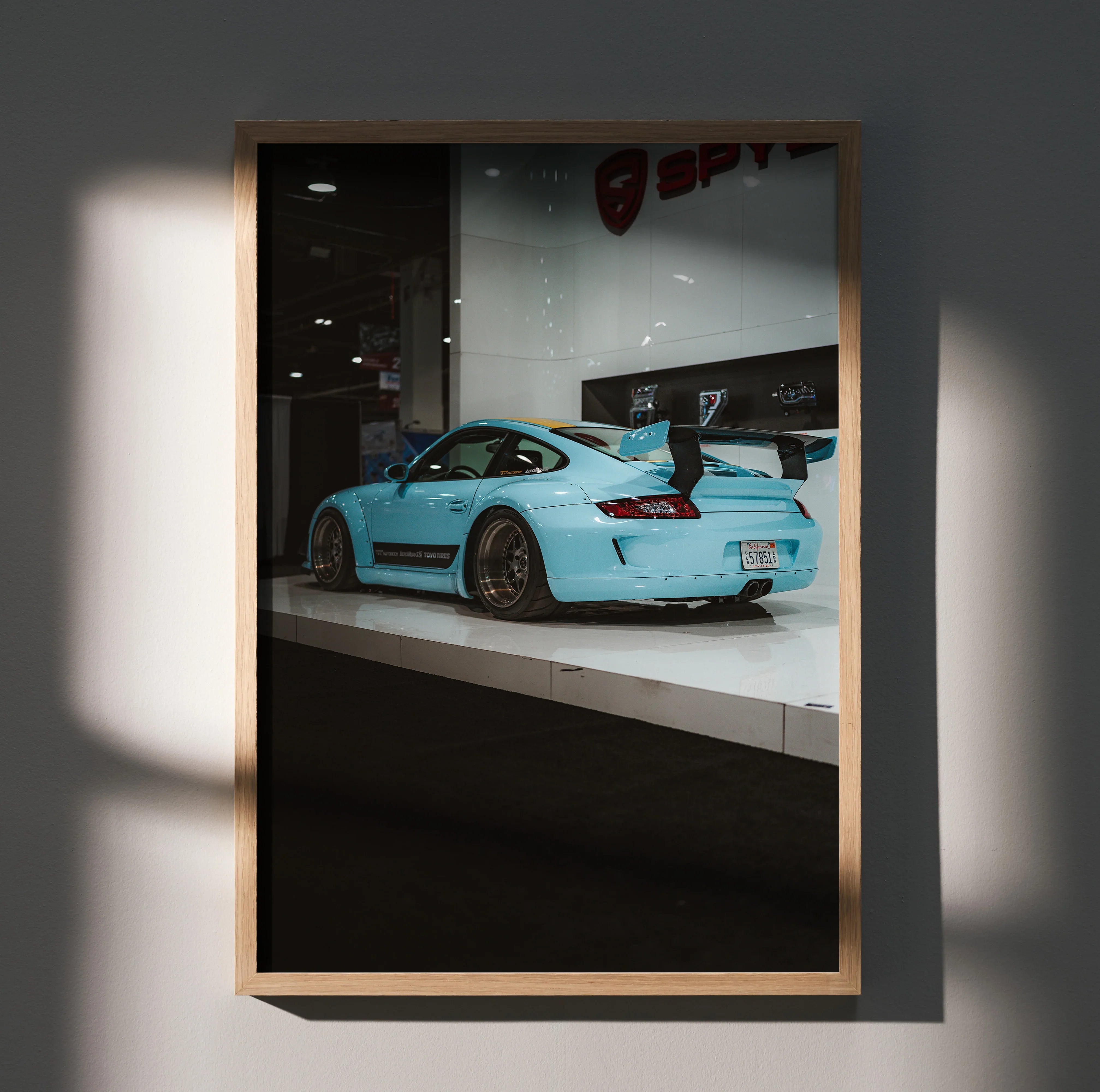 Porsche 911 Carrera 4 blue sports car reflected in showroom glass poster wall art with wooden frame.
