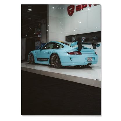Porsche 911 Carrera 4 light blue sports car with rear wing on glossy showroom poster wall art.