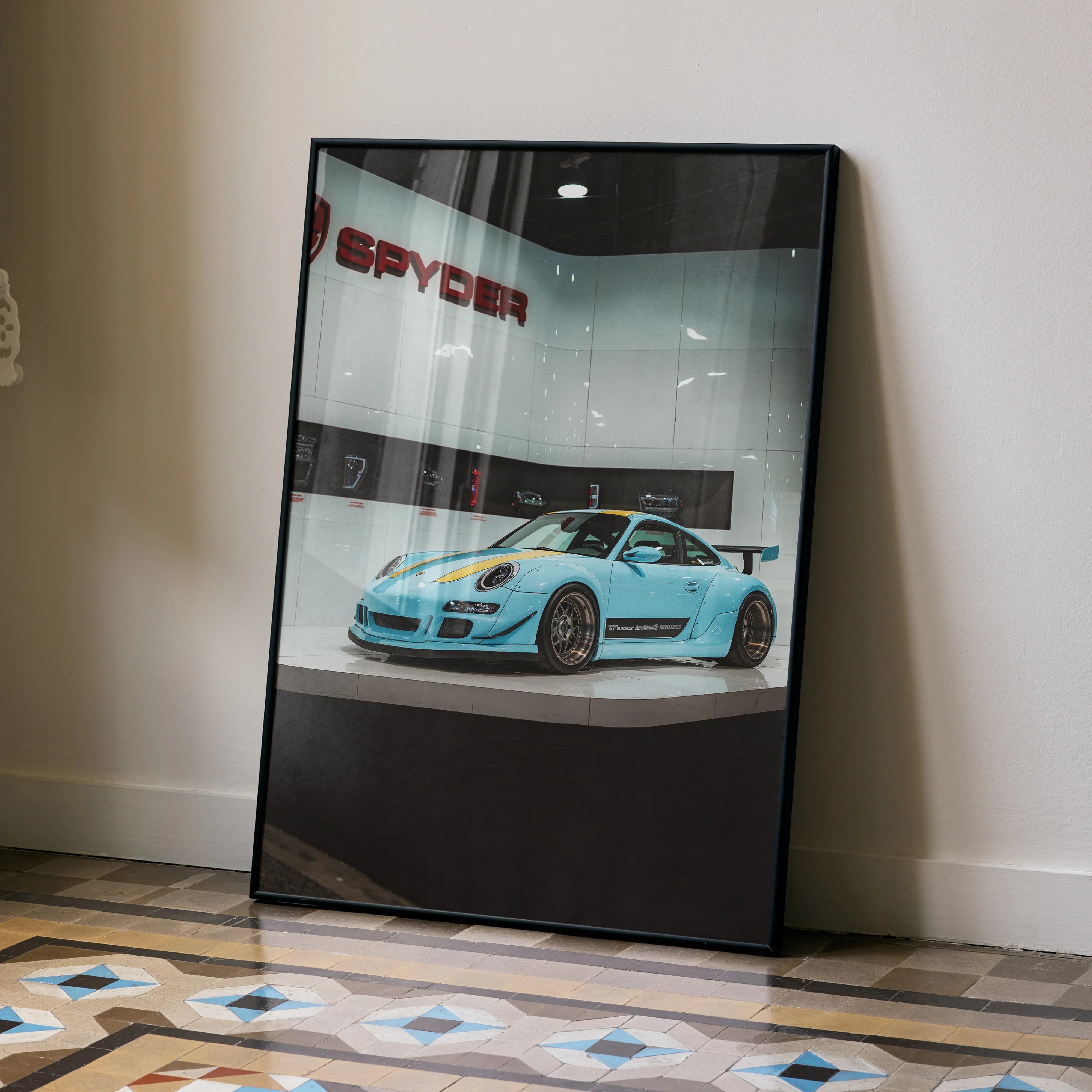 Blue Porsche 911 Carrera 4 poster wall art with sleek design leaning against wall.