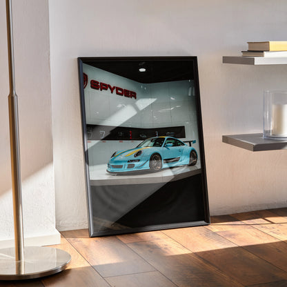 Porsche 911 Carrera 4 blue sports car poster in black frame leaning against white wall wall art.