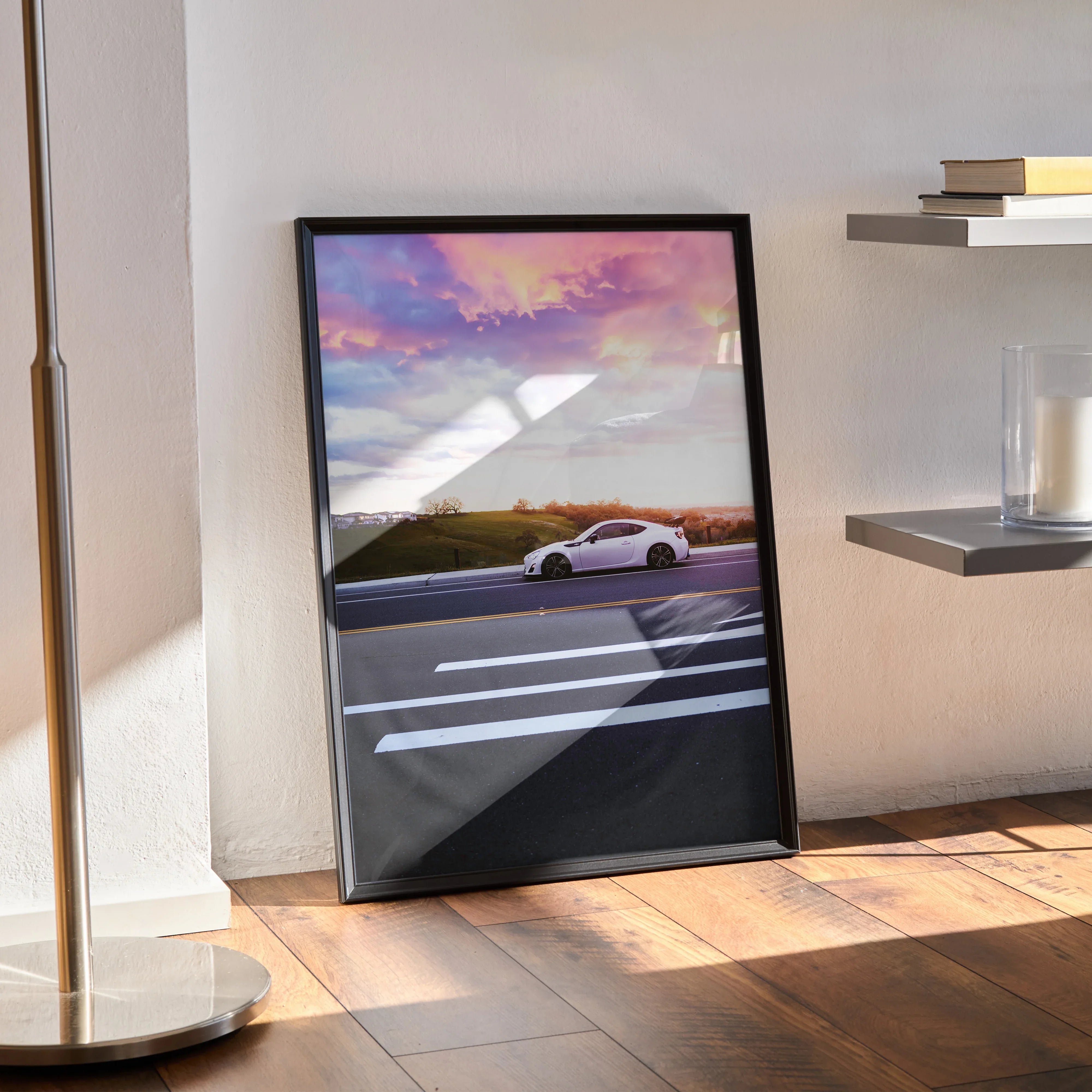 Toyota FRS car poster with sunset sky, modern wall art in black frame leaning on floor.