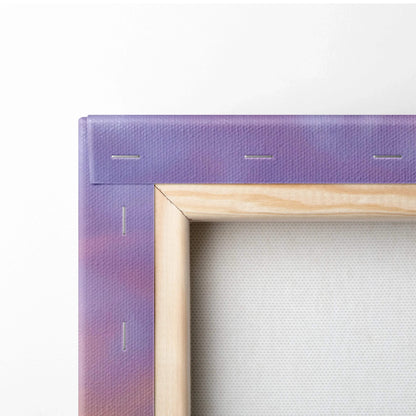 Close-up of canvas stretched over wooden frame showing purple sunset tones and texture of wall art canvas.