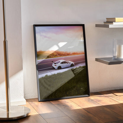 Toyota FRS poster with sunset background and sleek white sports car, modern wall art in black frame.