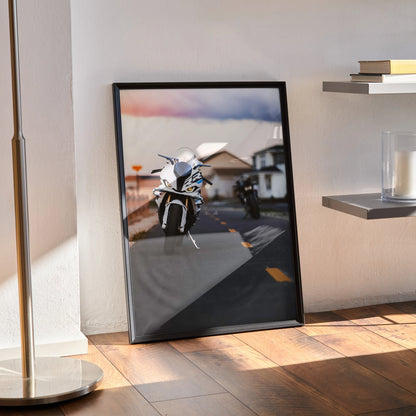 Framed poster wall art featuring BMW S1000RR and Aprilia RSV4 1100 motorcycles on a road at sunset.